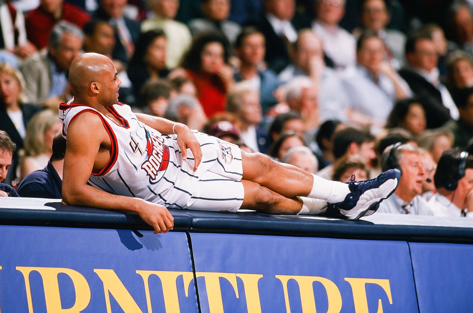 Charles Barkley of the Houston Rockets lays across the scorer's table in 1999.