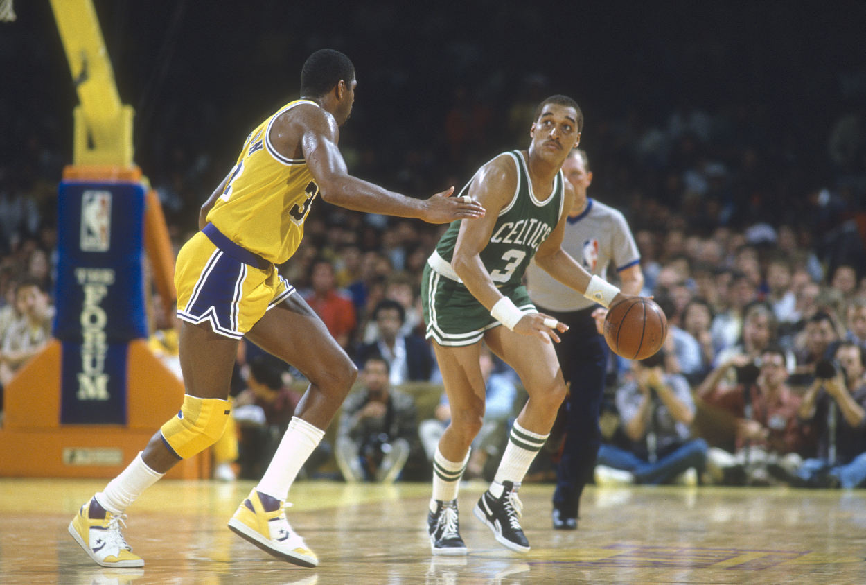 Dennis Johnson of the Boston Celtics dribbles the ball up court while guarded by Magic Johnson of the Los Angeles Lakers.