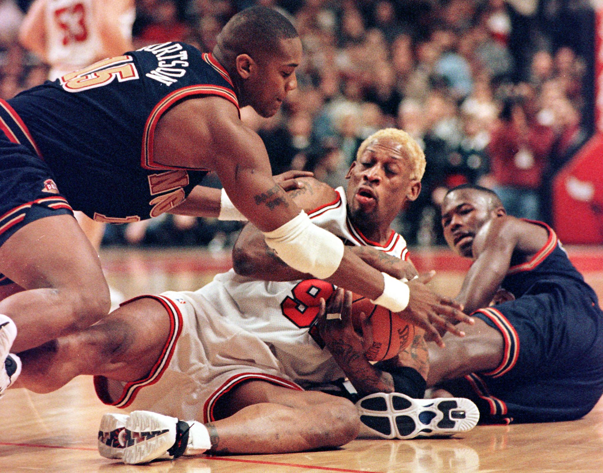 Chicago Bulls forward Dennis Rodman scrambles for the ball .