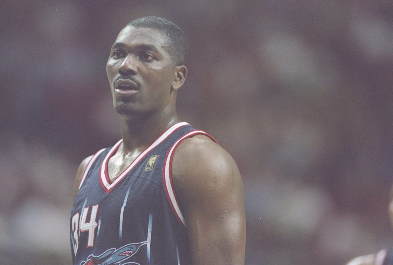 Rockets legend Hakeem Olajuwon looks on during a game in 1996