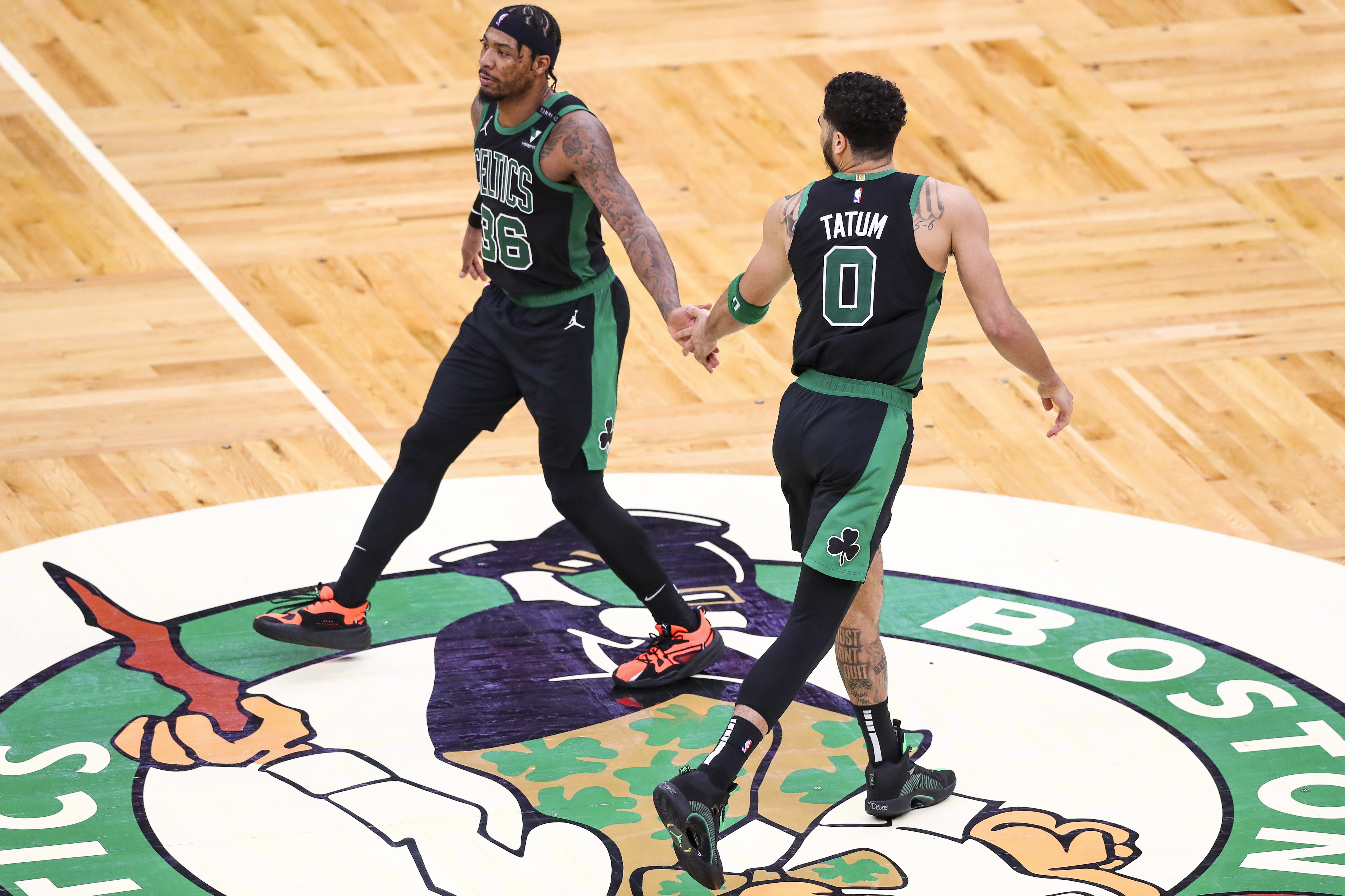 Celtics teammates Jayson Tatum and Marcus Smart high-five during a playoff game against the Brooklyn Nets