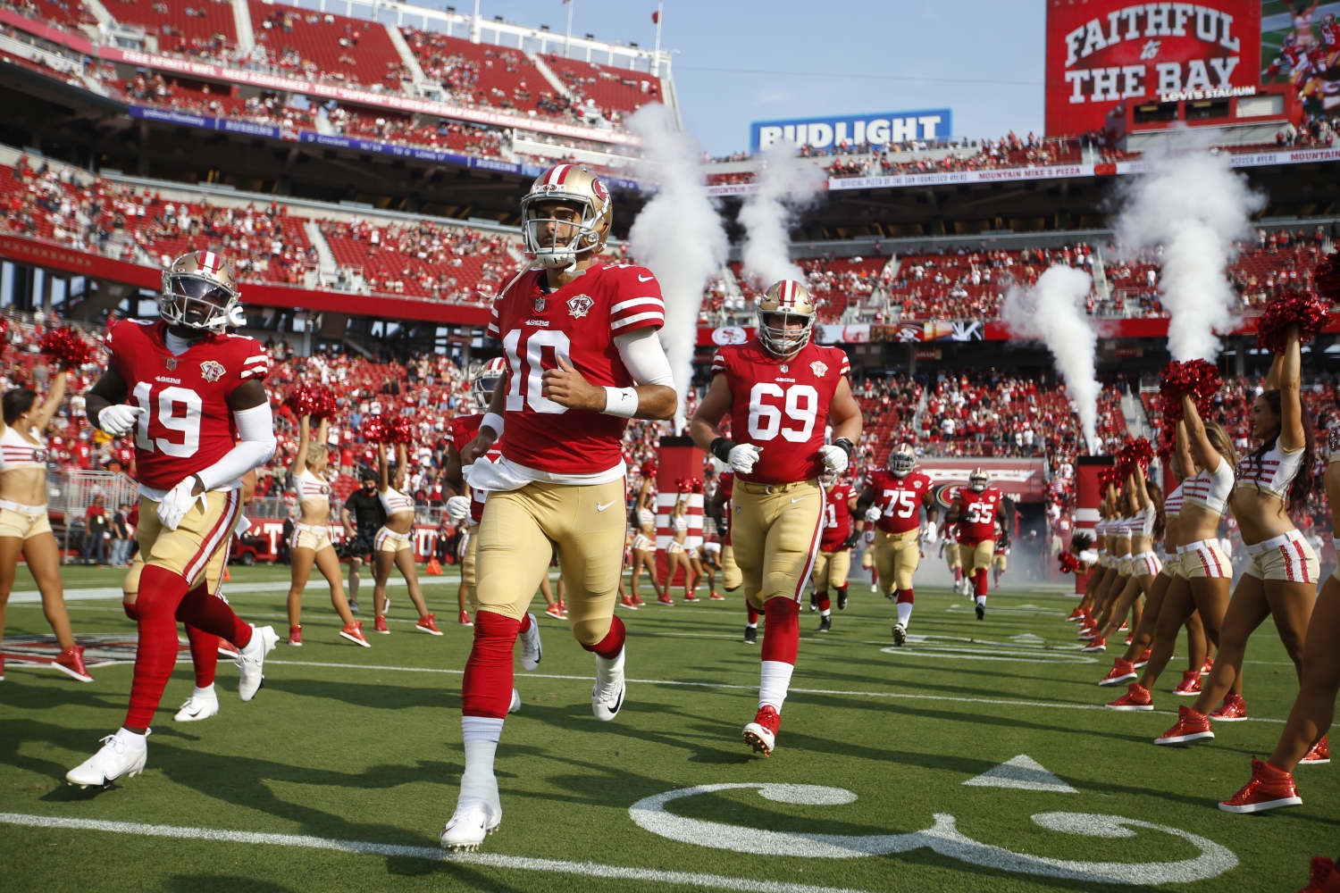 Jimmy Garoppolo jogs onto the field with his San Francisco 49ers teammates.