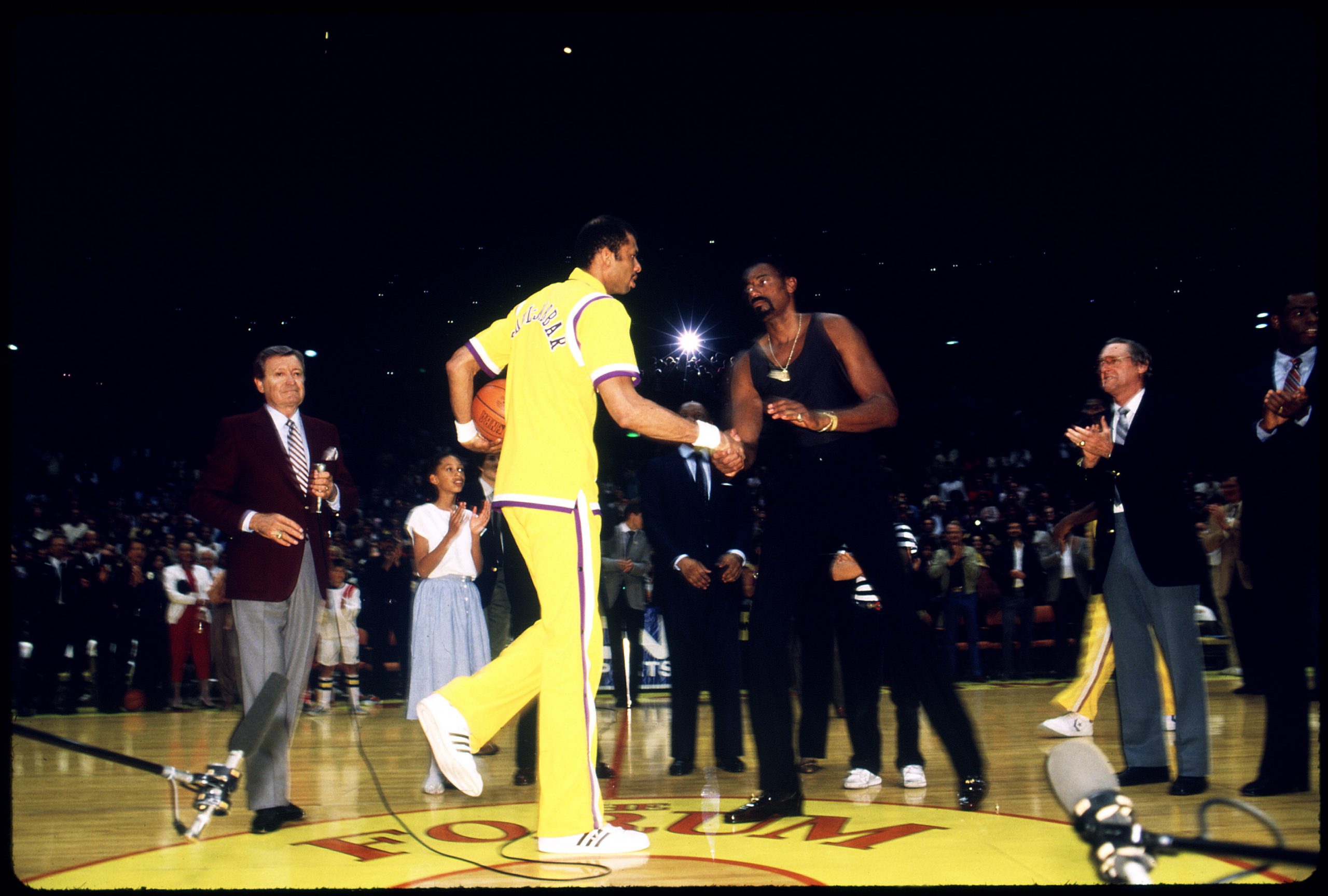 Kareem Abdul Jabbar shakes hands with Wilt Chamberlain.