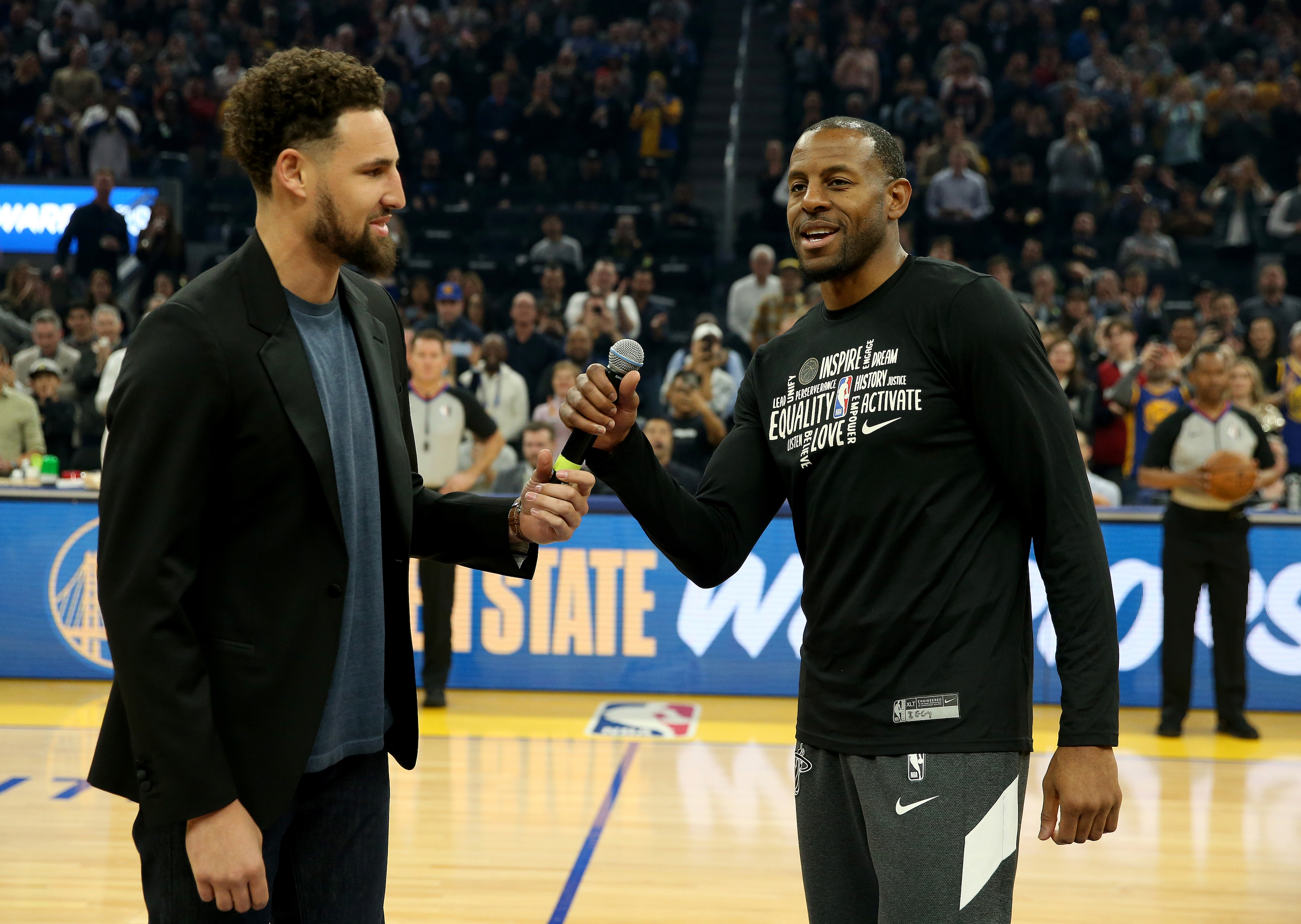Warriors star Klay Thompson passes the microphone to Andre Iguodala before a game in February of 2020