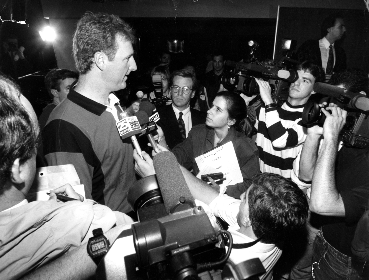 Members of the media swarm Larry Bird after he announced his retirement.