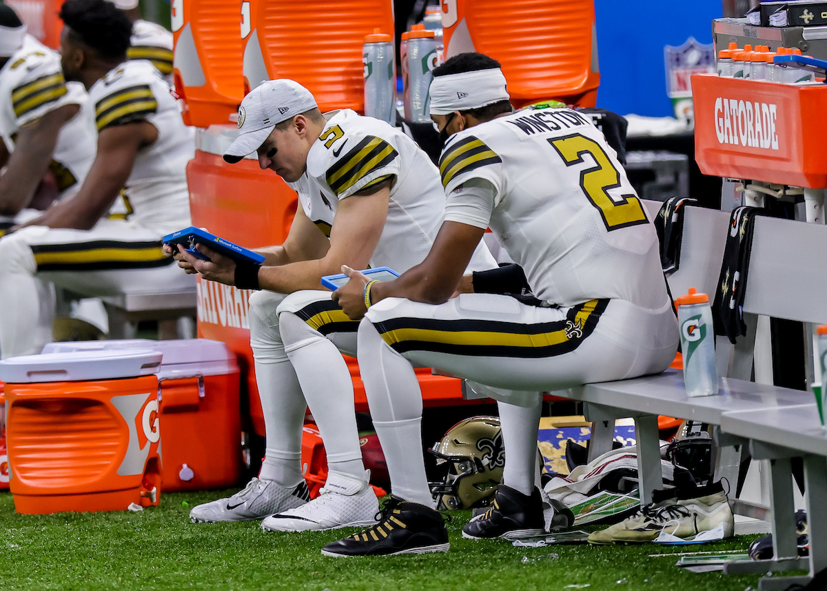 New Orleans Saints quarterbacks Drew Brees and Jameis Winston look over the defense on the sideline