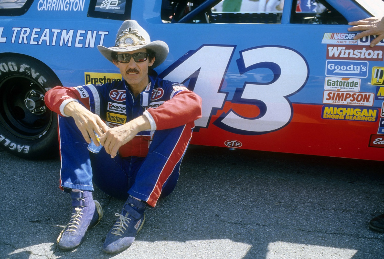 NASCAR driver Richard Petty in this portrait sitting next to the STP No. 43 car Feb. 15, 1987, before the Daytona 500 at Daytona International Speedway.