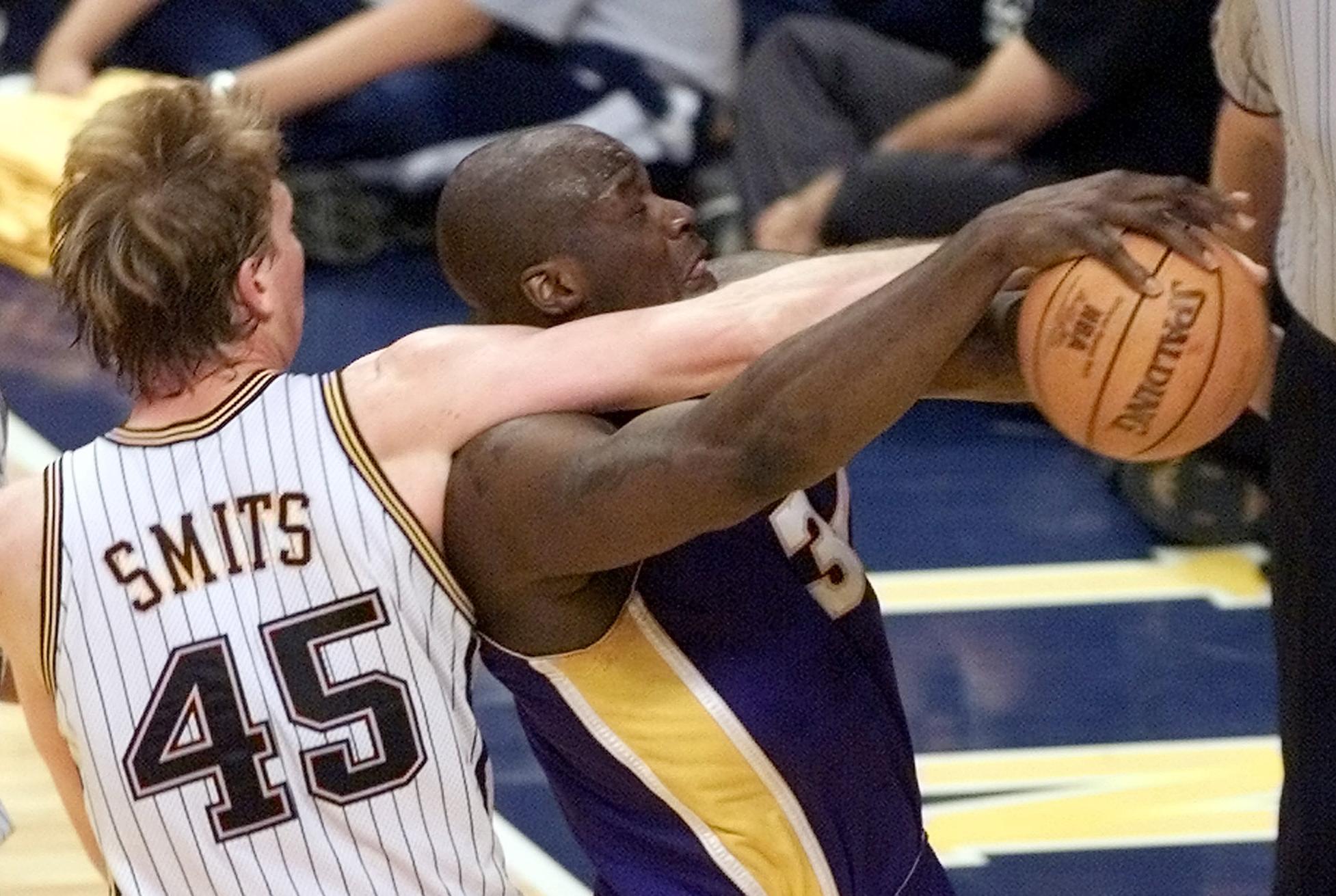 Former Lakers star Shaquille O'Neal and Pacers center Rik Smits fight for the ball during the 2000 NBA Finals