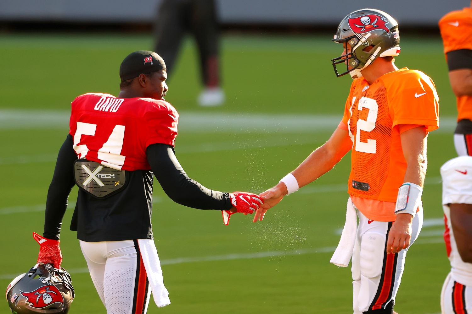 Buccaneers linebacker Lavonte David shakes hands with Tom Brady during practice.
