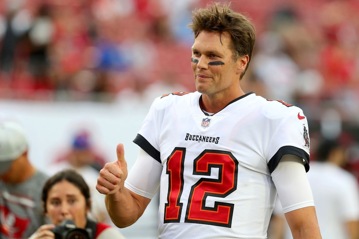 Tampa Bay Buccaneers quarterback Tom Brady gives a thumbs up to a fan in the end zone.