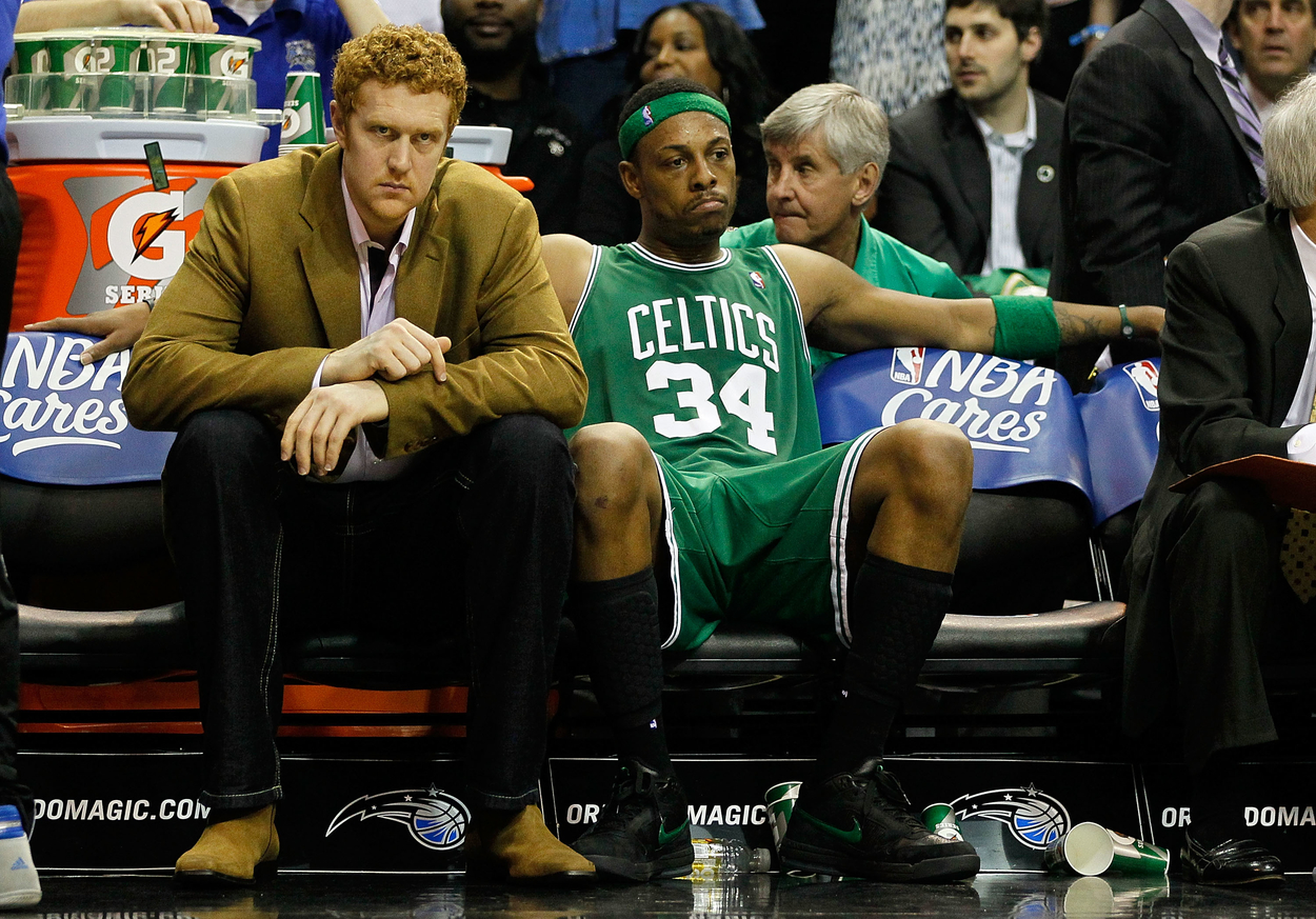 Brian Scalabrine, in a suit, sits next to Paul Pierce on the bench during the Eastern Conference Finals.