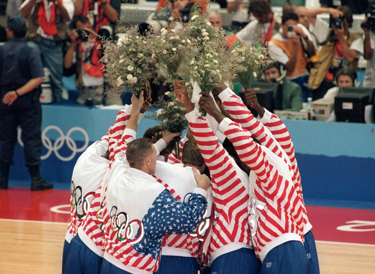 The United States Dream Team lifts their flowers in the air to celebrate winning a gold medal.