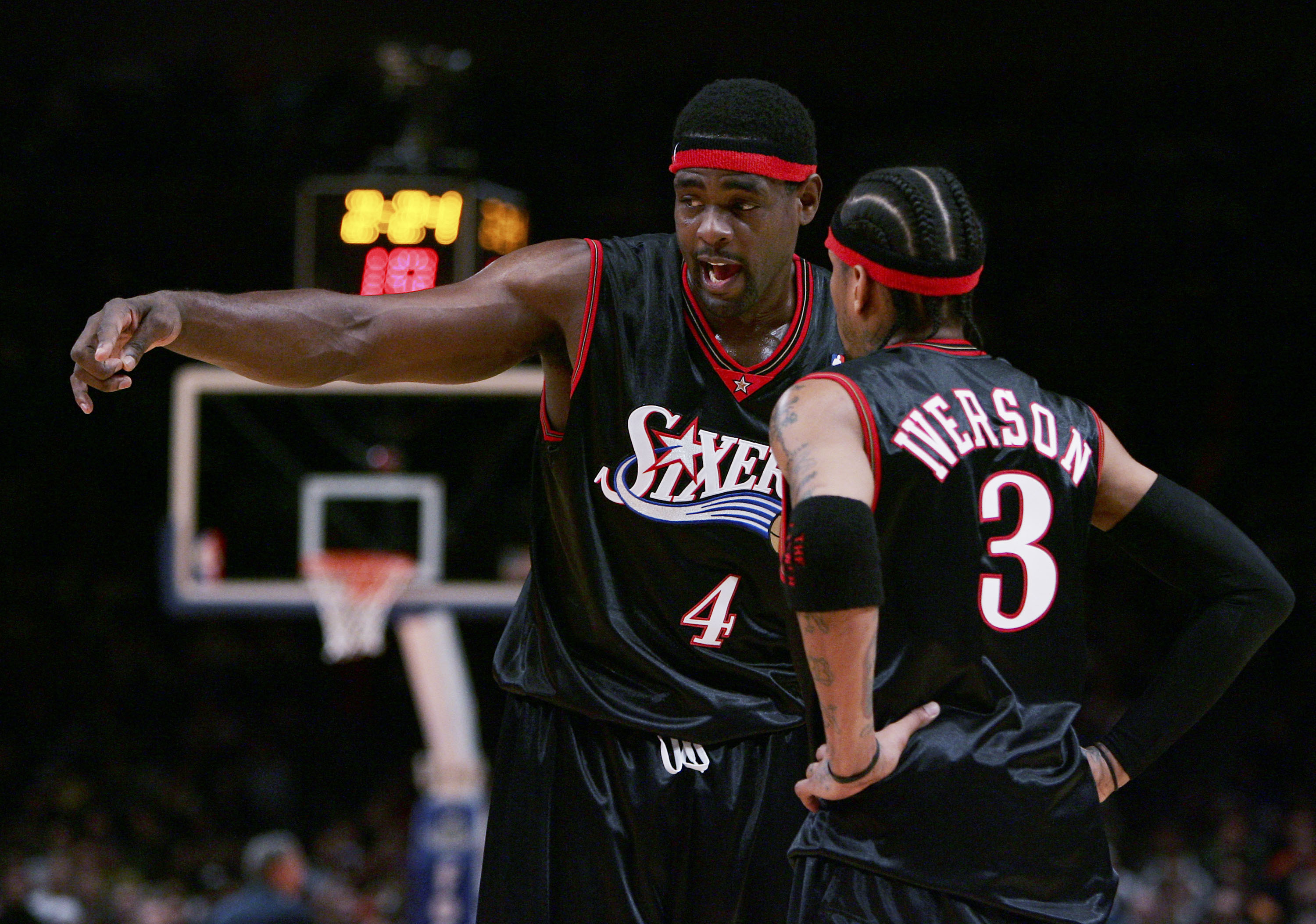 Former teammates Chris Webber and Allen Iverson talk during a Philadelphia 76ers game in November 2005