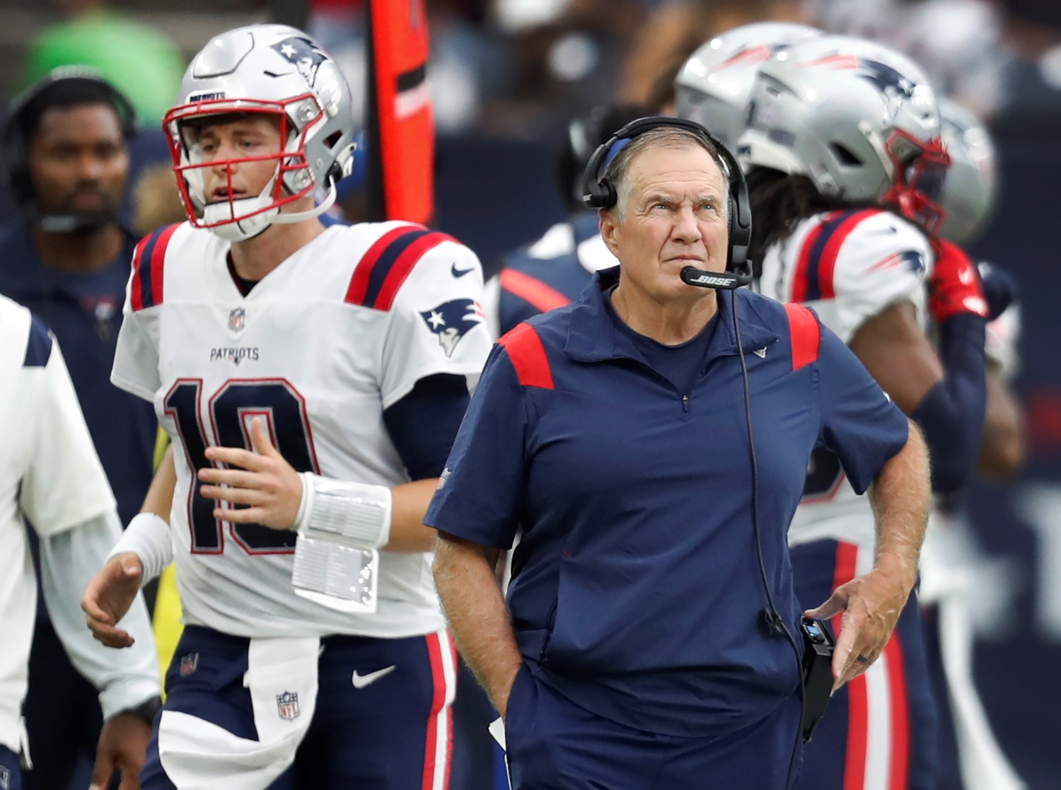 New England Patriots head coach Bill Belichick looks up as Mac Jones makes his way to the sideline following an interception.