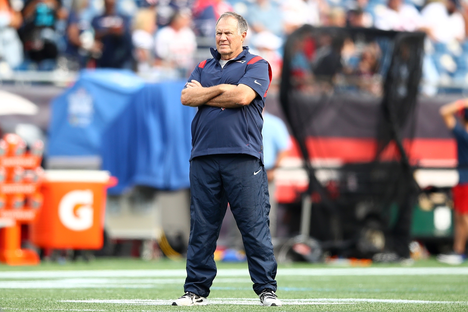 New England Patriots head coach Bill Belichick watches his team warm up before a game against the Miami Dolphins.