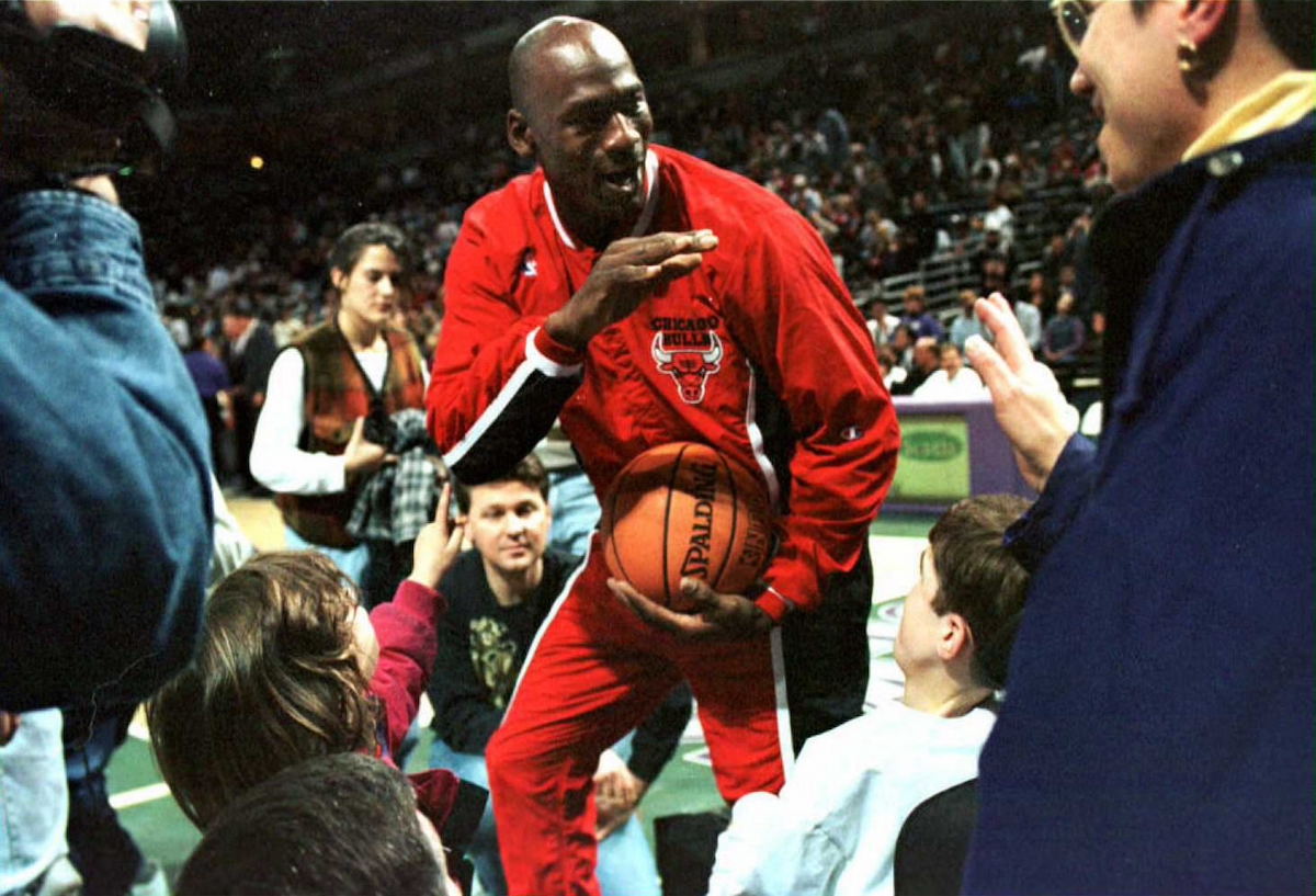 Chicago Bulls player Michael Jordan greets fans before a game in 1996