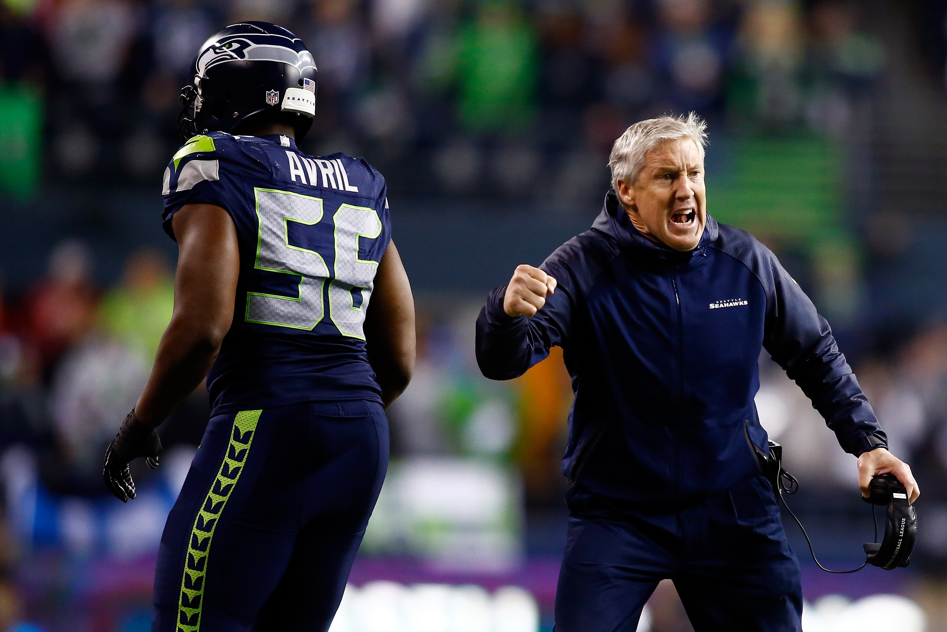 Seahawks defensive end Cliff Avril runs off the field while Pete Carroll yells