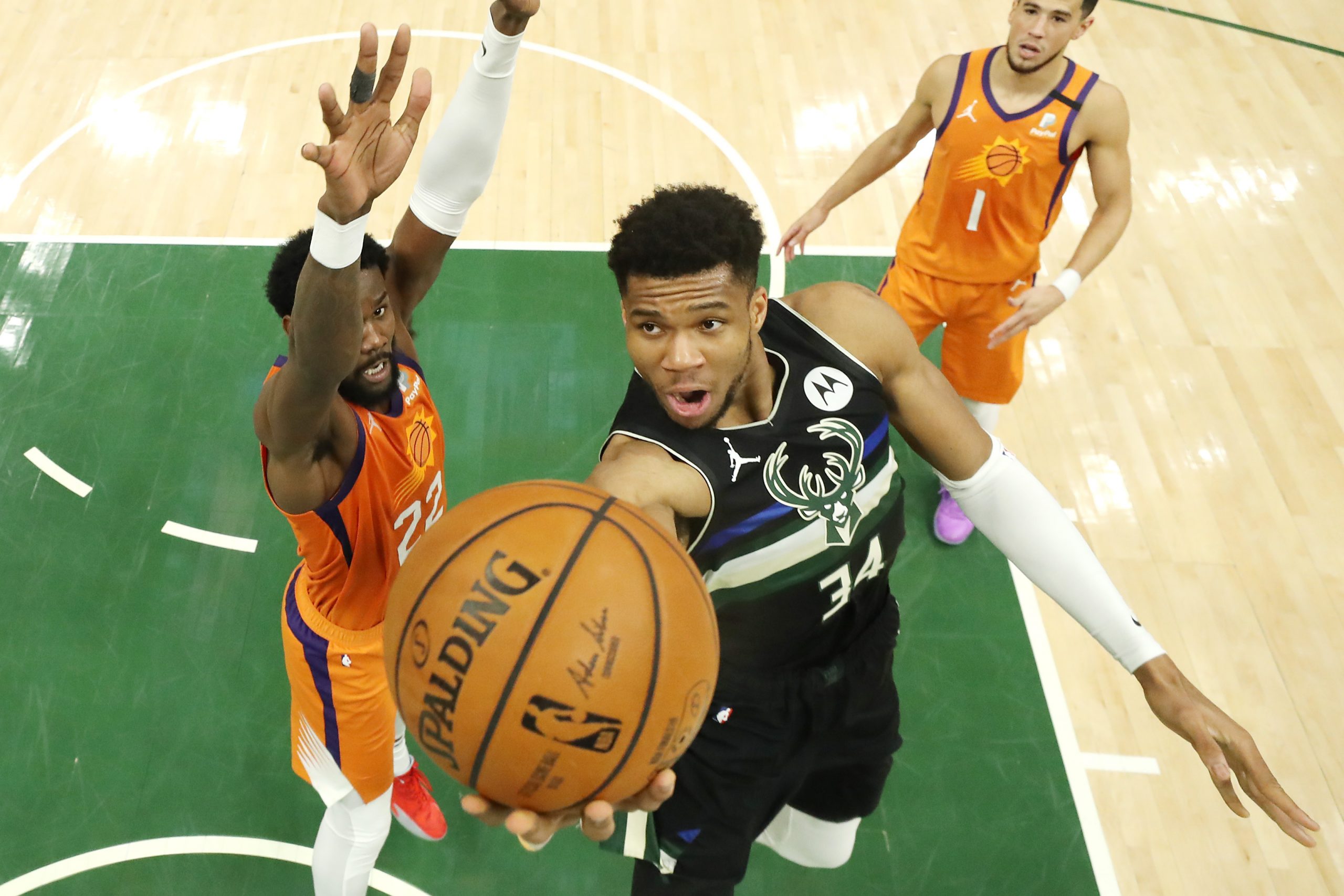 Giannis Antetokounmpo of the Milwaukee Bucks goes up for a shot against Deandre Ayton of the Phoenix Suns.