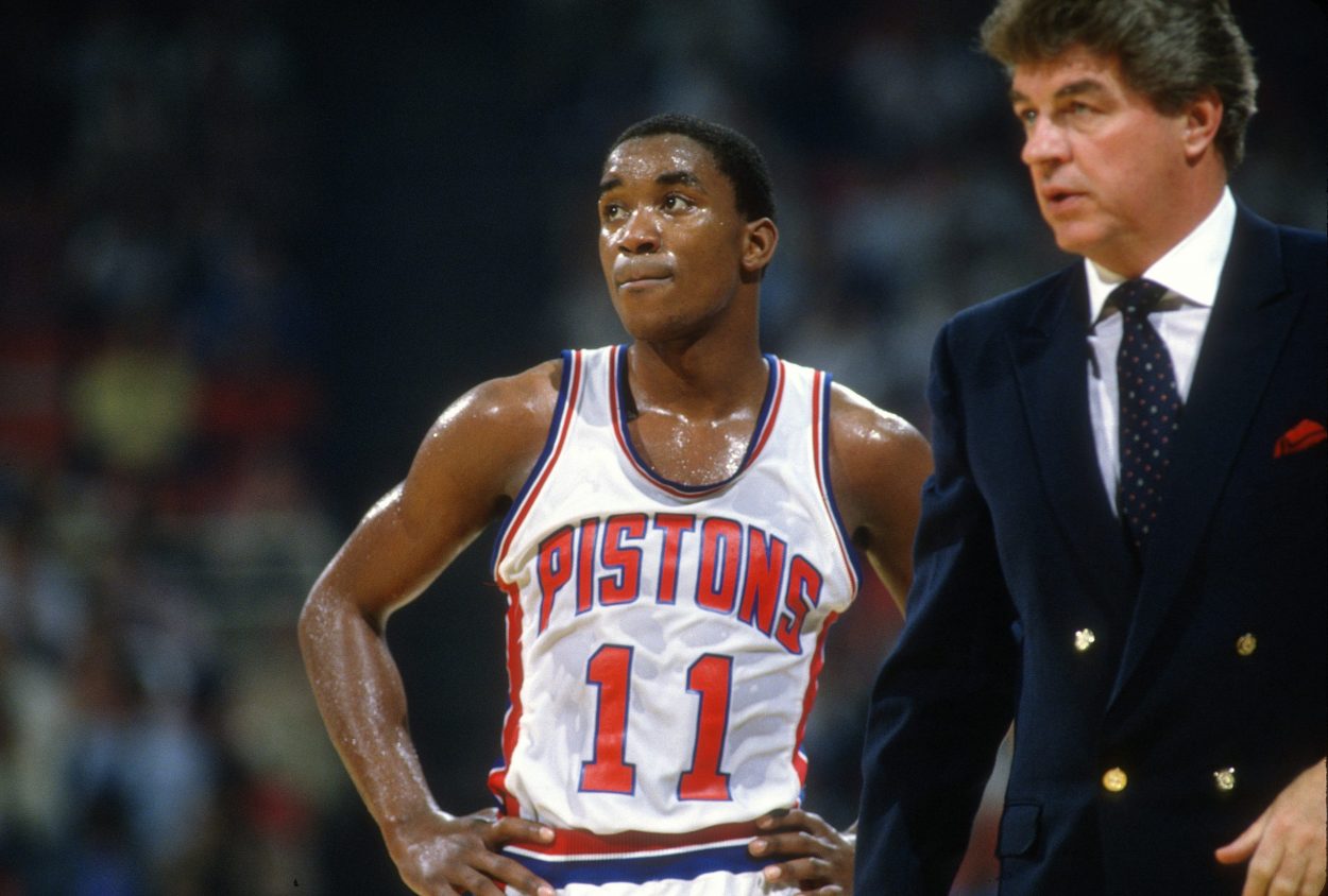 Pistons great Isiah Thomas and former head coach Chuck Daly look on during a game in 1987