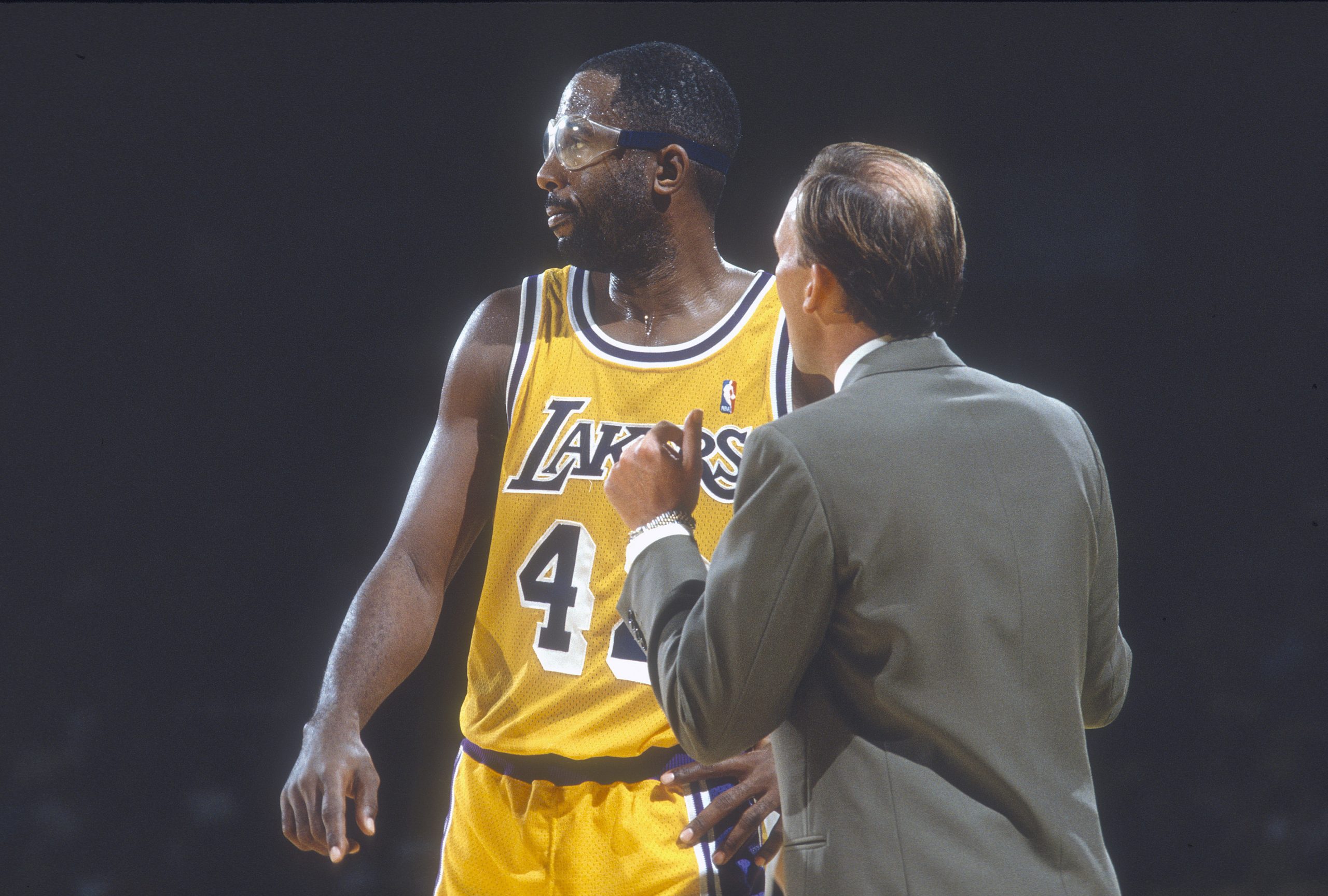 James Worthy of the Los Angeles Lakers talks with head coach Mike Dunleavy.