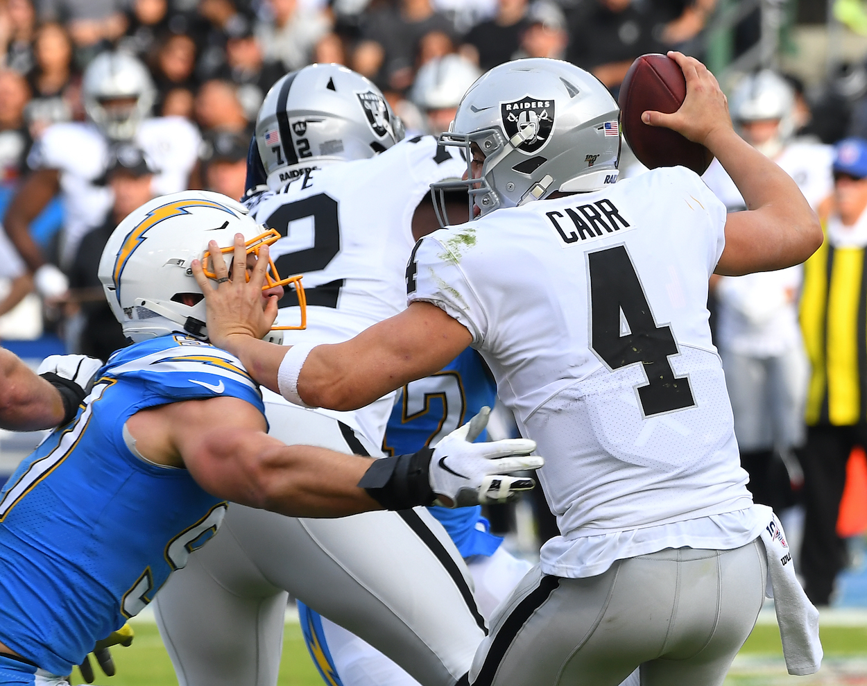 Quarterback Derek Carr of the Oakland Raiders is sacked by defensive end Joey Bosa of the Los Angeles Chargers in the first half of the game at Dignity Health Sports Park on December 22, 2019 in Carson, California.
