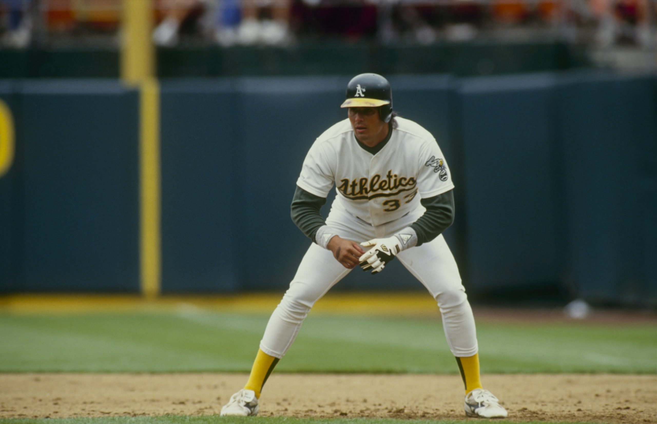 Jose Canseco of the Oakland Athletics leads off first base.
