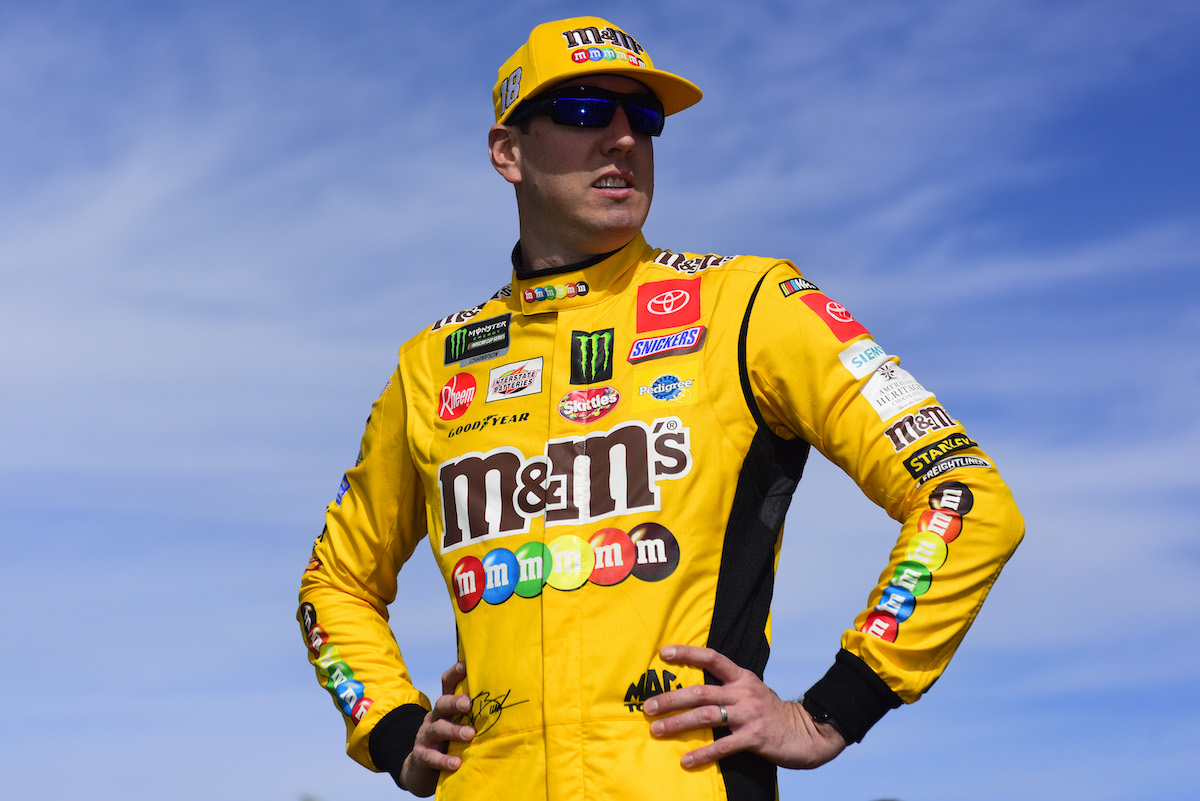 Kyle Busch, driver of the #18 M&M's Halloween Toyota, stands on the grid before the Monster Energy NASCAR Cup Series Hollywood Casino 400 at Kansas Speedway on October 20, 2019, in Kansas City, Kansas