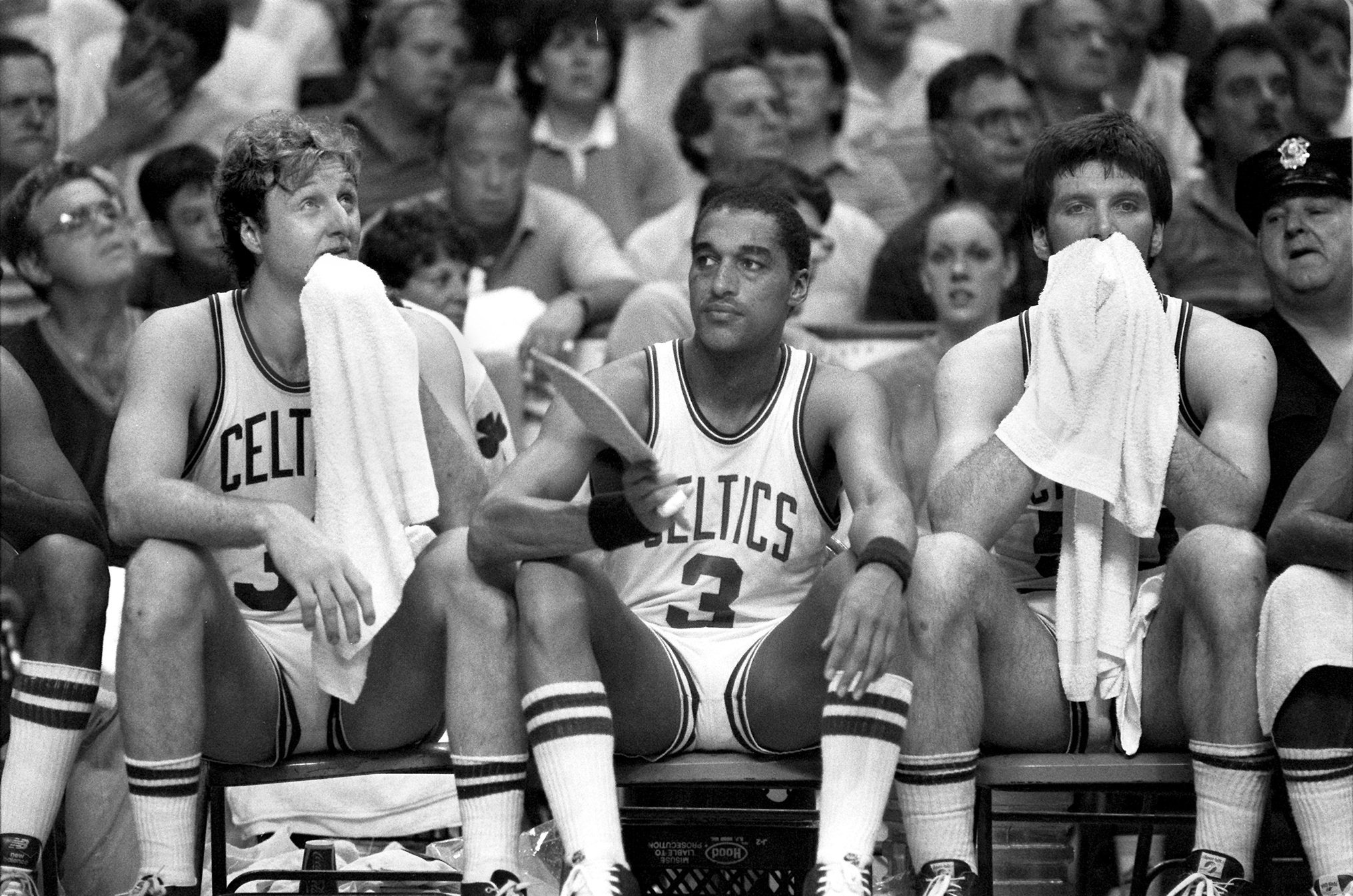 Larry Bird, left, and Greg Kite, right, try to stay cool while Dennis Johnson fans himself as the Boston Celtics play the Los Angeles Lakers at Boston Garden on June 8, 1984.