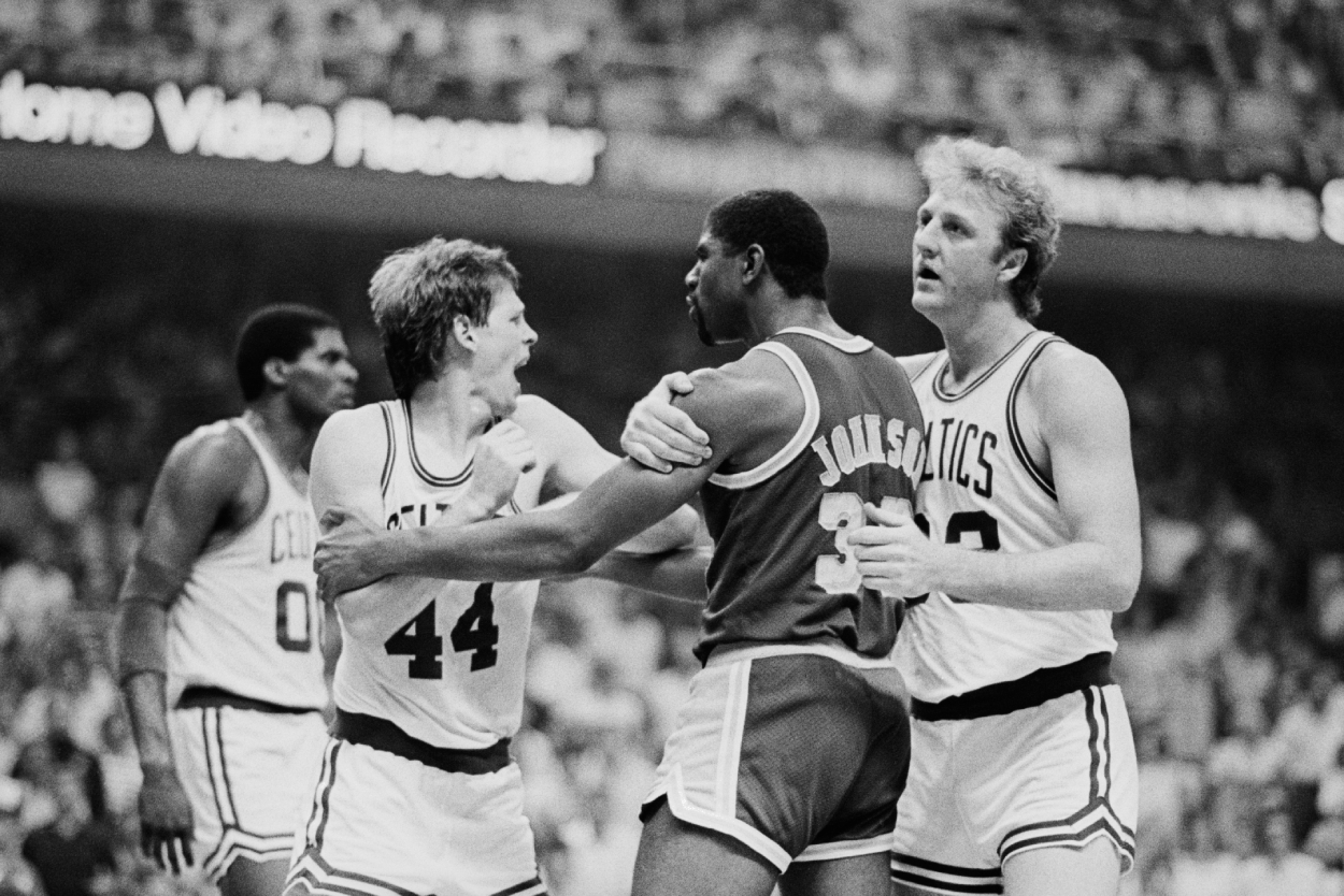 Boston Celtics' basketball player Larry Bird restrains Los Angeles Lakers' Magic Johnson from punching Celtics' Danny Ainge.