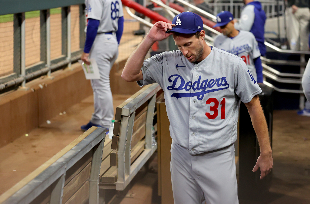 Max Scherzer of the Los Angeles Dodgers stands in the dugout after he was taken out of the game against the Atlanta Braves.