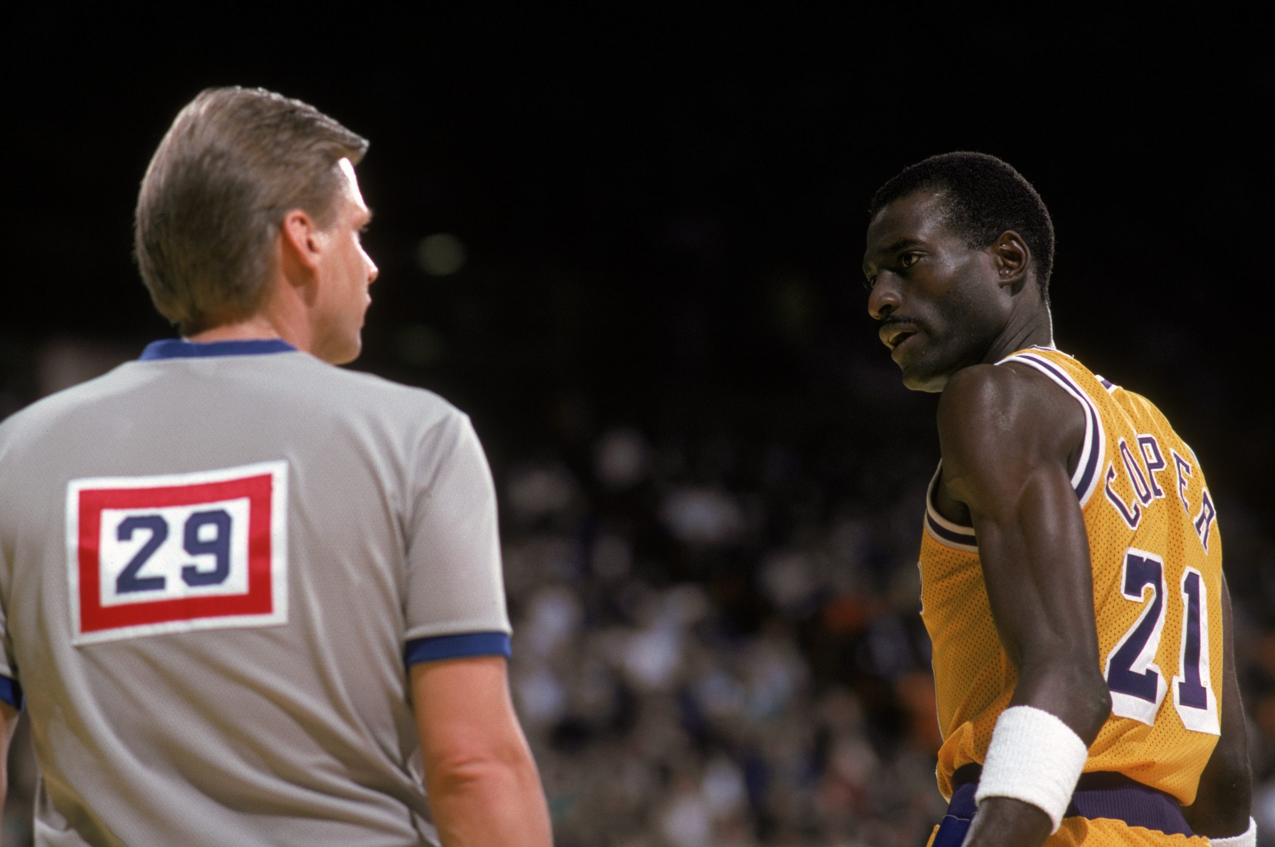 Michael Cooper of the Los Angeles Lakers talks to a referee.
