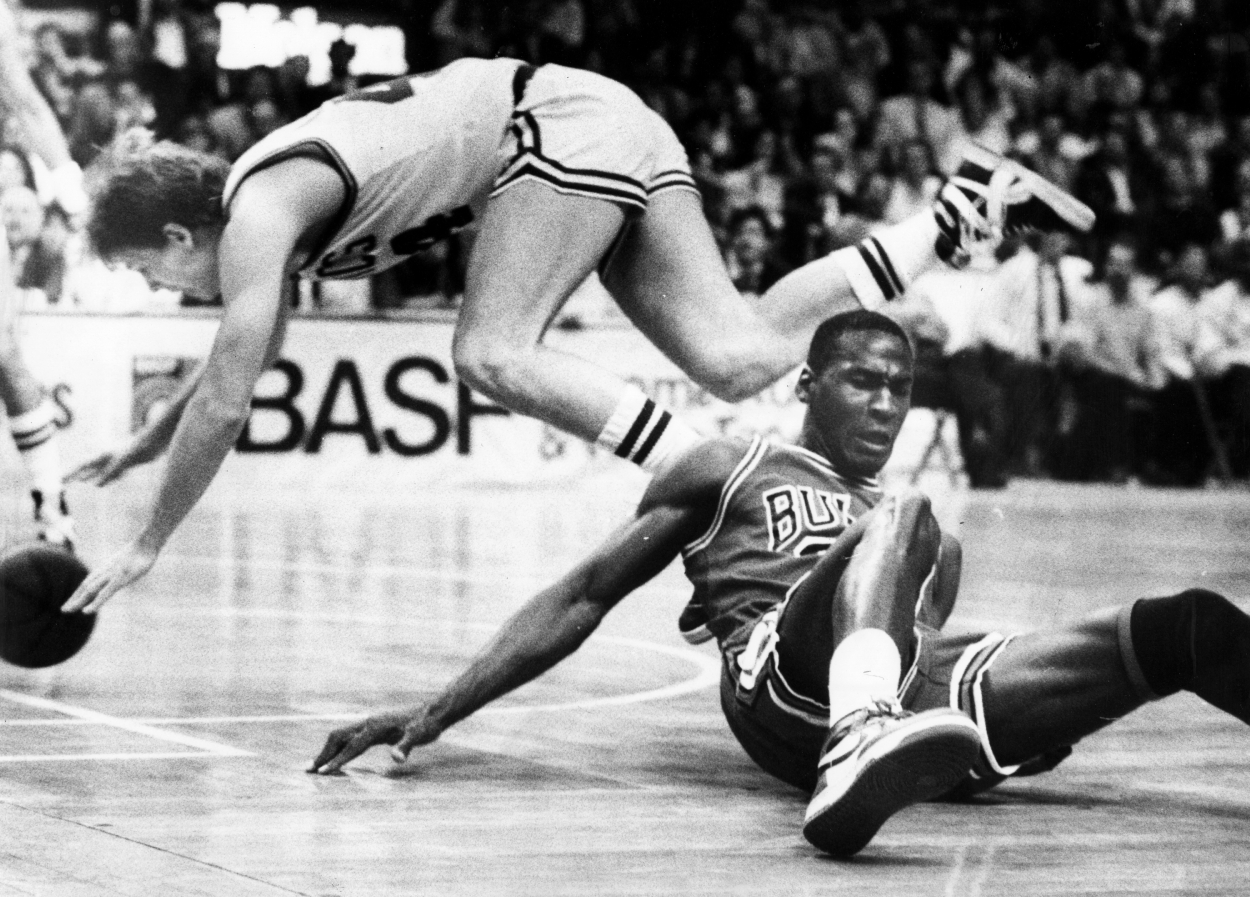 Boston Celtics player Danny Ainge, top, and Chicago Bulls player Michael Jordan, bottom right, fall, during a game.