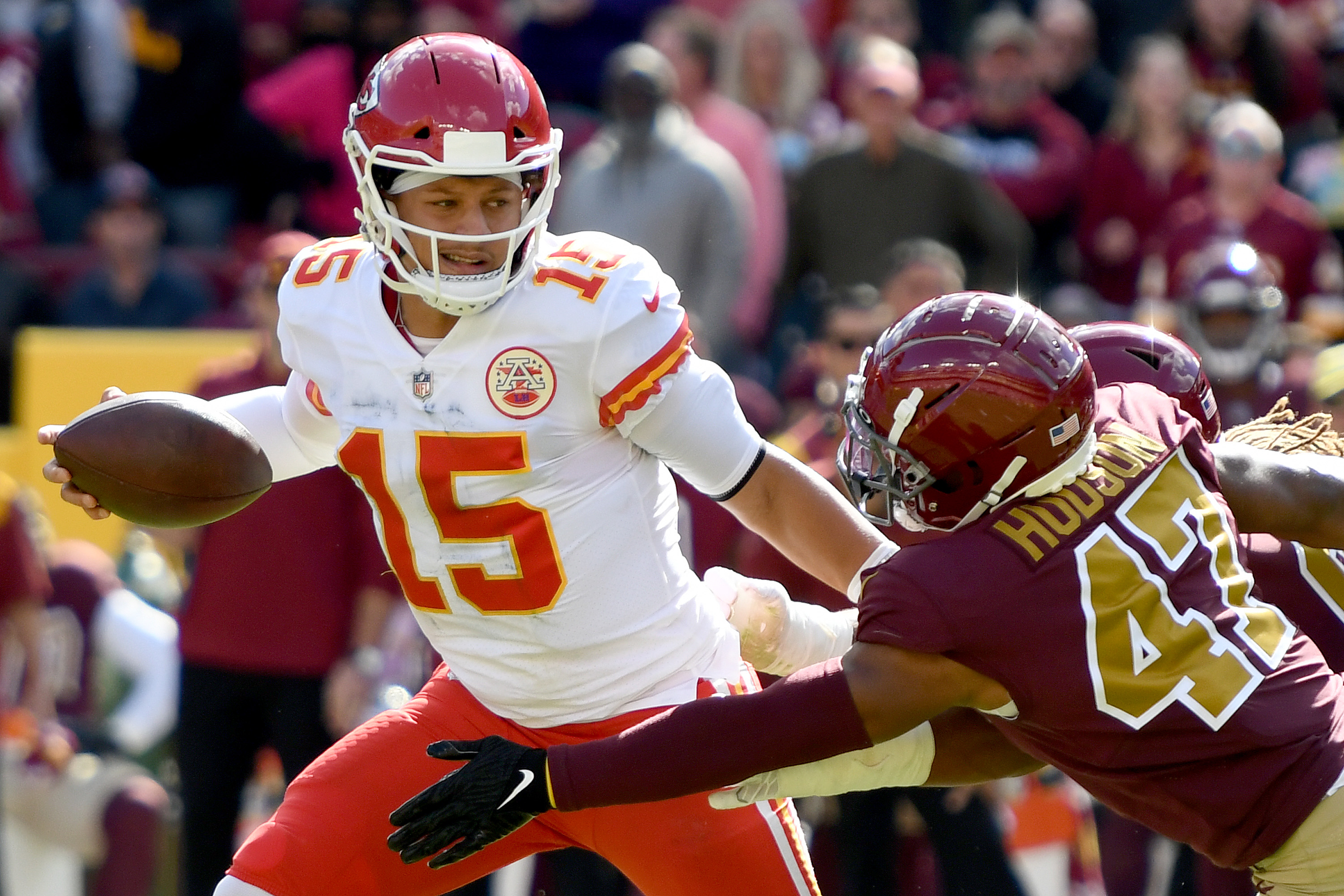 Chiefs quarterback Patrick Mahomes fending off Washington Football Team defenders