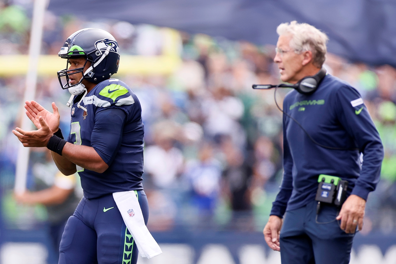 Seattle Seahawks QB Russell Wilson encourages his team as Pete Carroll watches.
