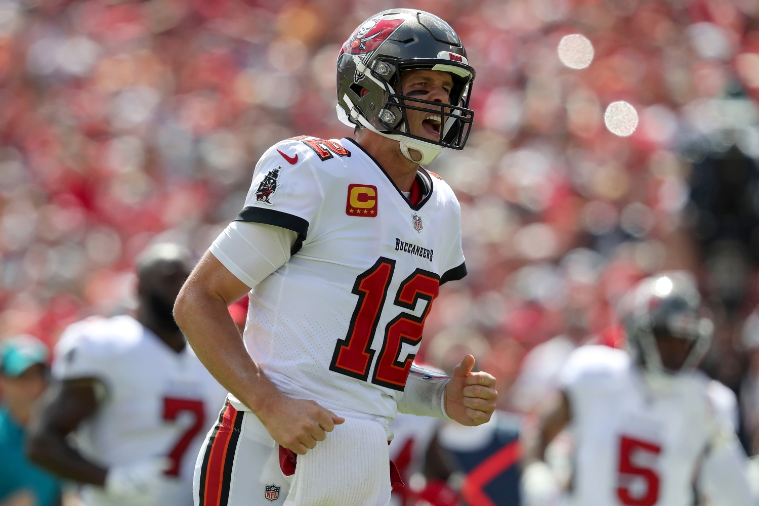 Tampa Bay Buccaneers quarterback Tom Brady jogs over to celebrate throwing a touchdown pass to Antonio Brown.