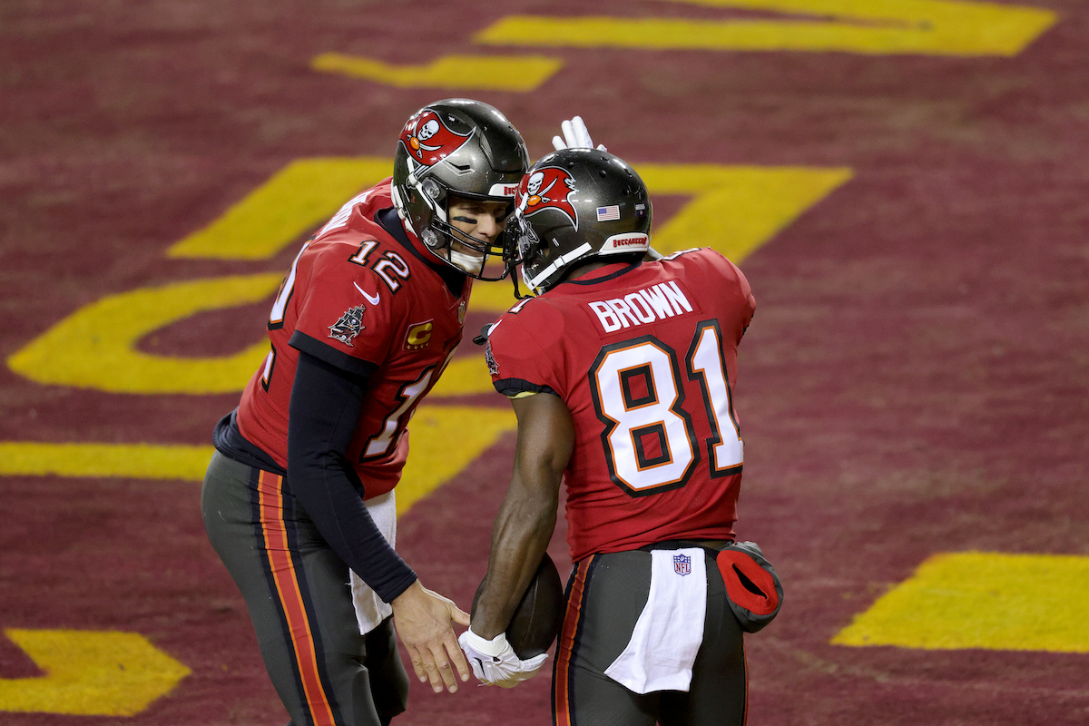 Tom Brady and Antonio Brown of the Tampa Bay Buccaneers celebrate after connecting for a first-half touchdown pass against the Washington Football Team in the NFC Wild Card playoff game at FedExField on January 9, 2021, in Landover, Maryland