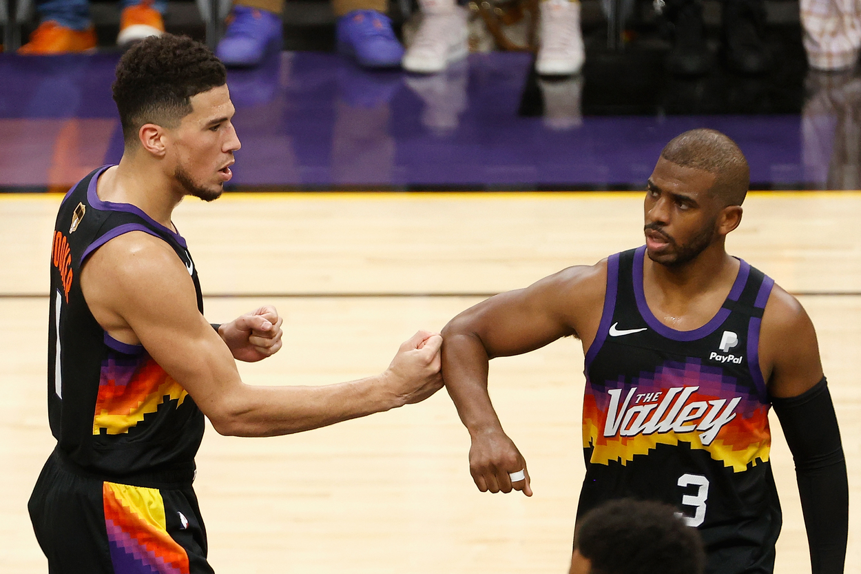 Phoenix Suns guards Devin Booker and Chris Paul acknowledge each other with a bump.
