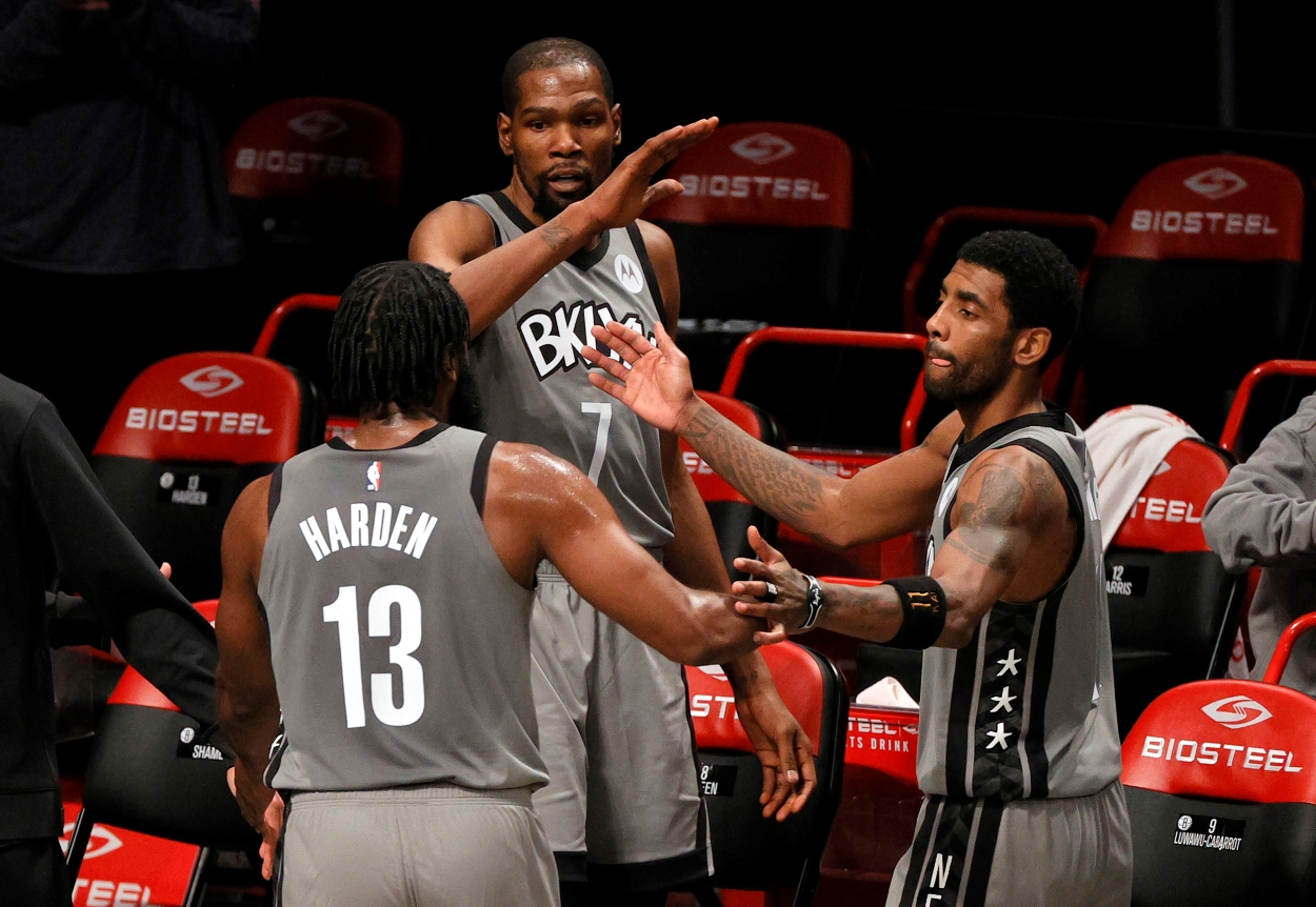 Kevin Durant, James Harden, and Kyrie Irving of the Brooklyn Nets high five on their way off the court.