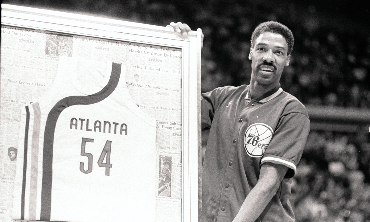 Julius Erving holds a framed No. 54 Atlanta Hawks jersey from his short stint with the club in 1972, where he teamed with legendary Pete Maravich for a few preseason games