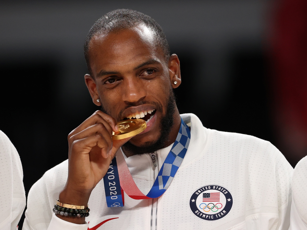 The Milwaukee Bucks' Khris Middleton bites his Olympic gold medal from the 2020 Tokyo Games.