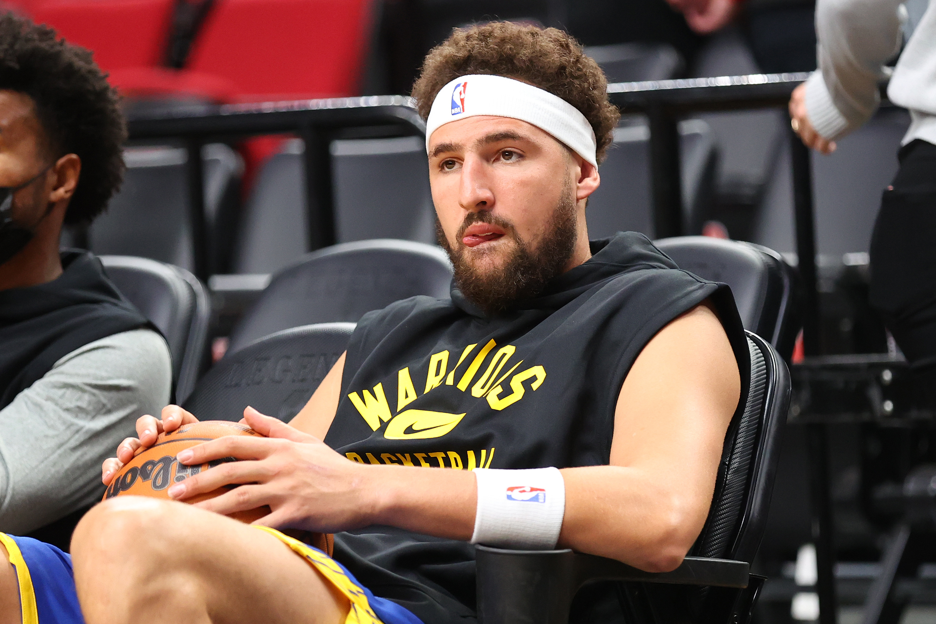 Klay Thompson watching the Golden State Warriors from a seat in the arena.