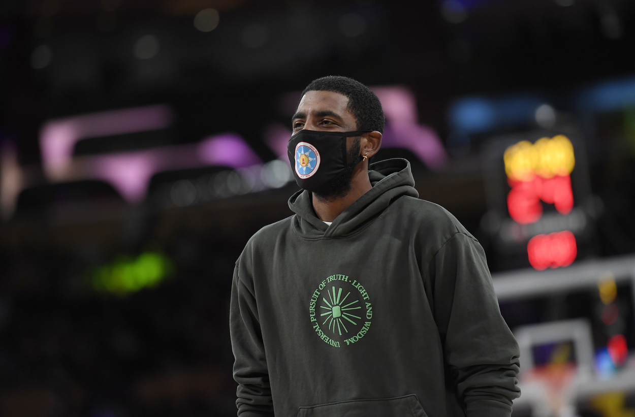 Brooklyn Nets point guard Kyrie Irving wearing a sweatshirt during a preseason game.