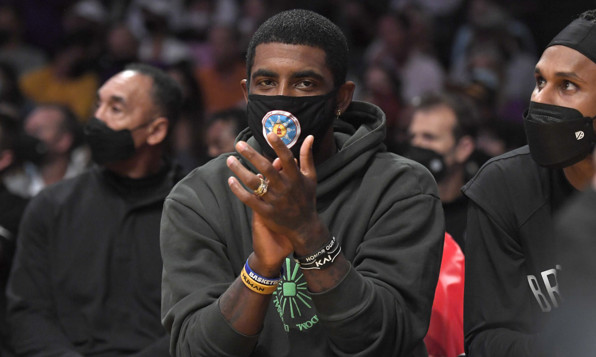 Kyrie Irving was on the bench with the Brooklyn Nets for their preseason opener in LA, but won't be with the team until his vaccination status is resolved or New York City lifts its vaccine mandate