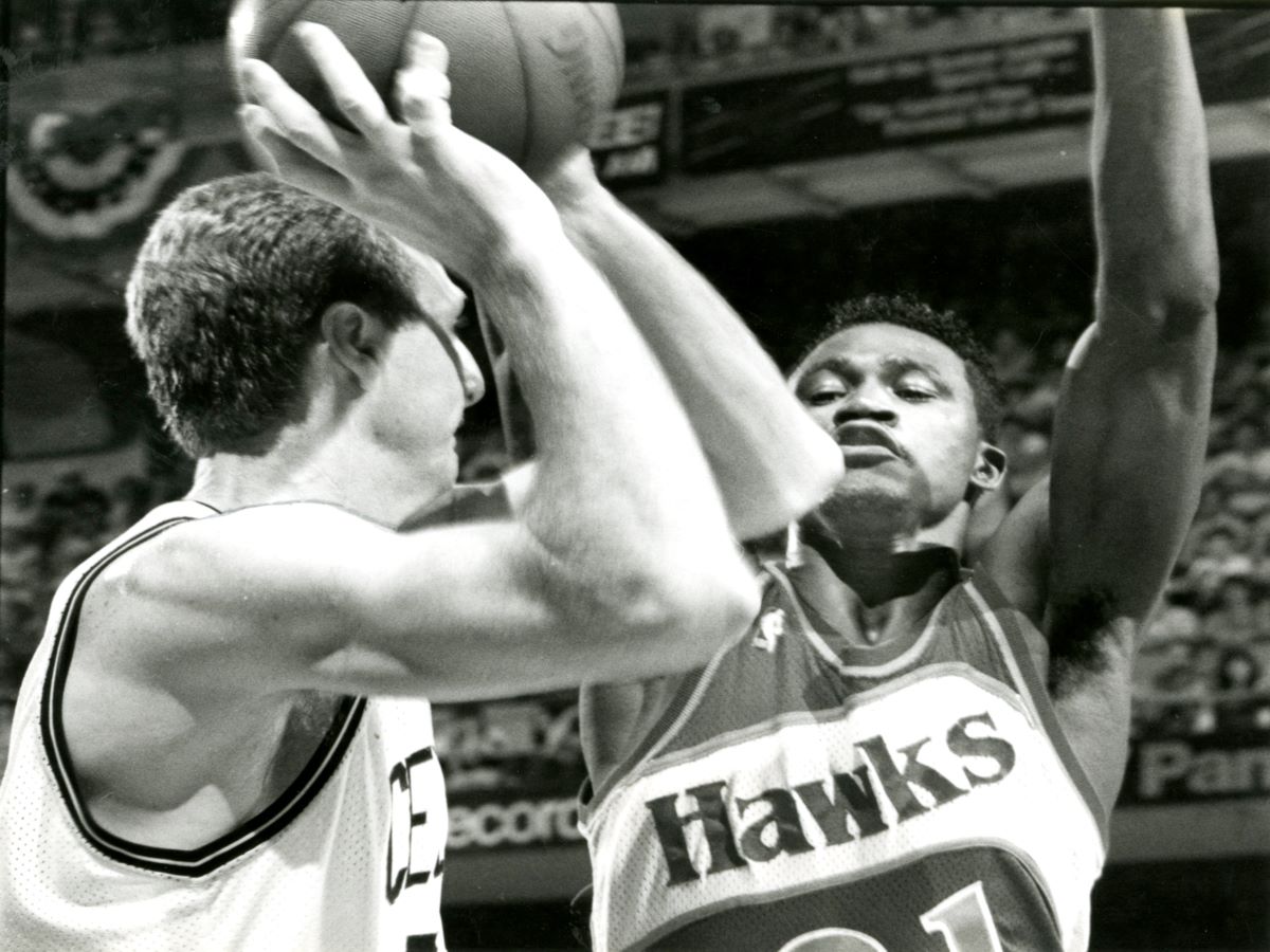 The Boston Celtics' Larry Bird is guarded by the Atlanta Hawks' Dominique Wilkins.