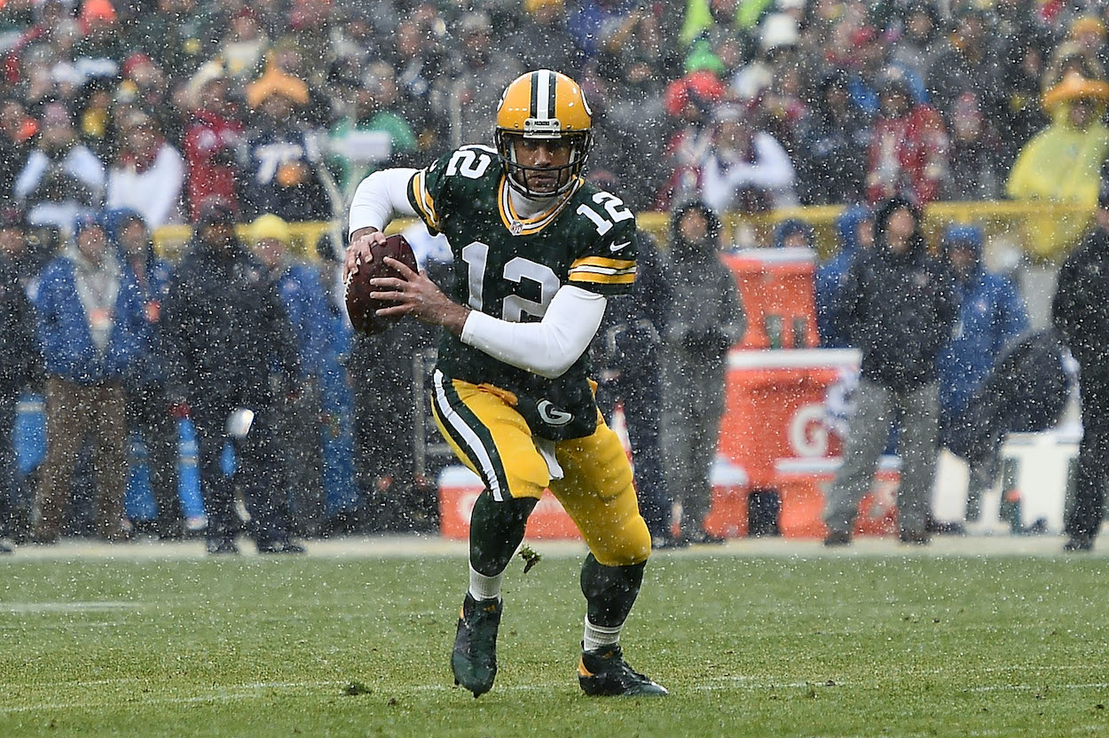 Aaron Rodgers scrambles in the snow