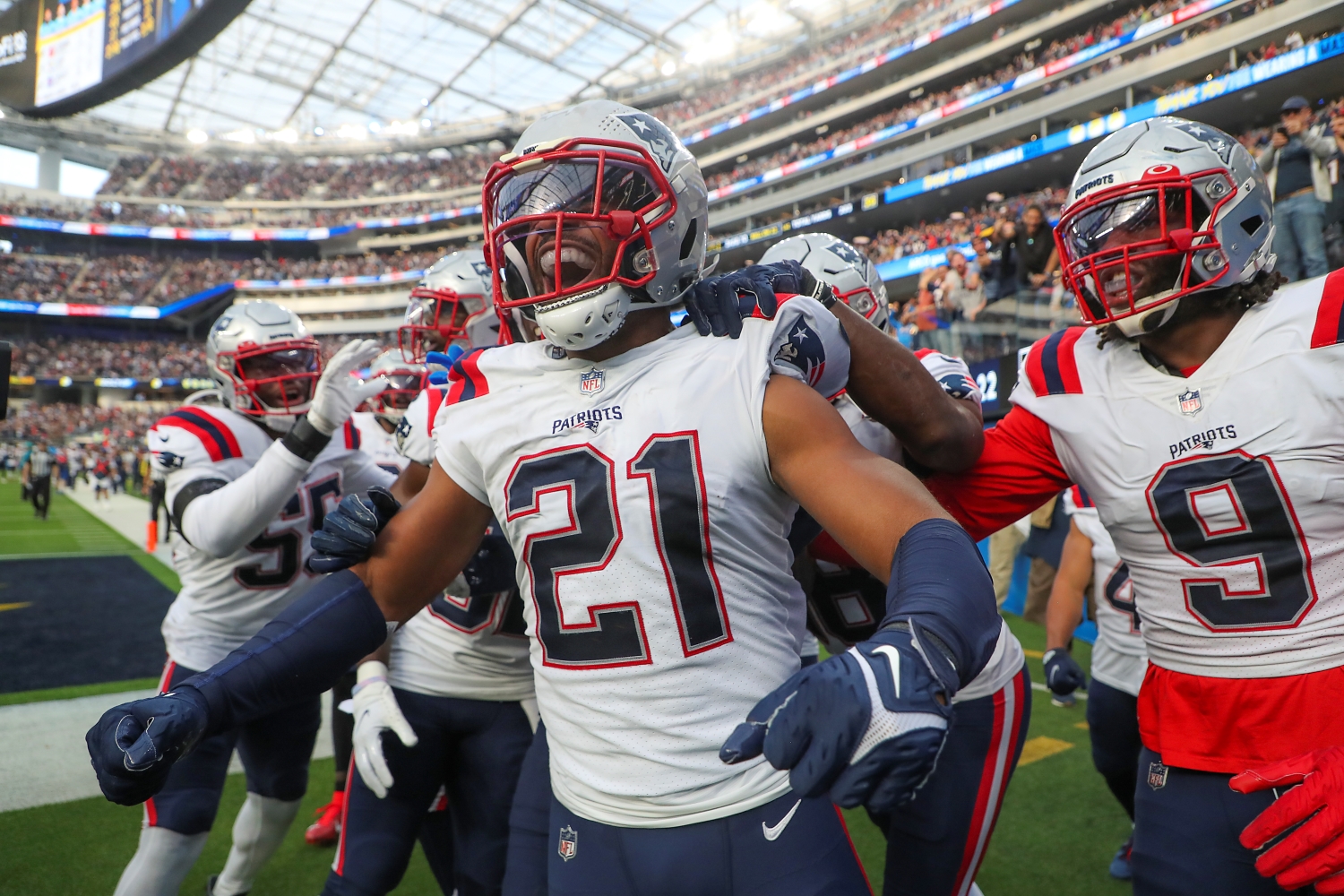 Former Los Angeles Chargers safety Adrian Phillips celebrates recording an interception for a touchdown with his New England Patriots teammates.