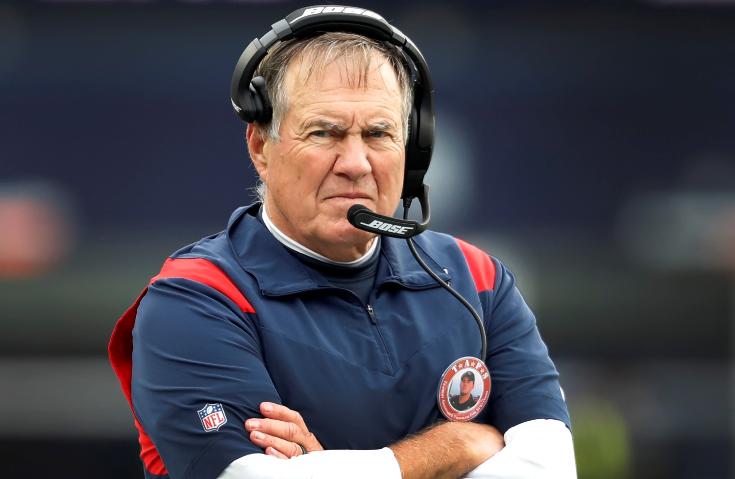 New England Patriots head coach Bill Belichick watches his team with his arms crossed.