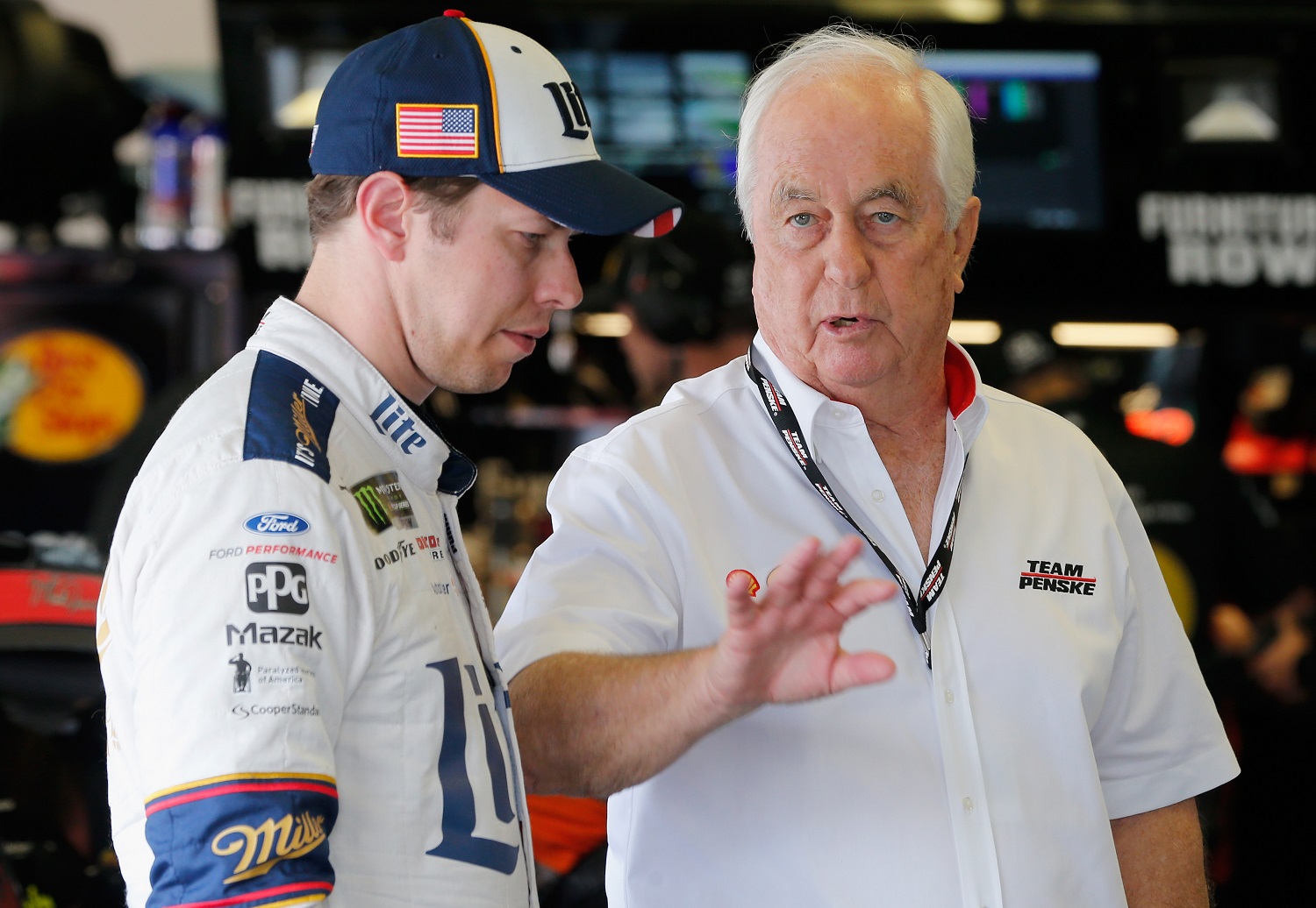 Brad Keselowski talks with team owner Roger Penske in the garage area during practice for the 59th Annual Daytona 500 at Daytona International Speedway on Feb. 24, 2017.