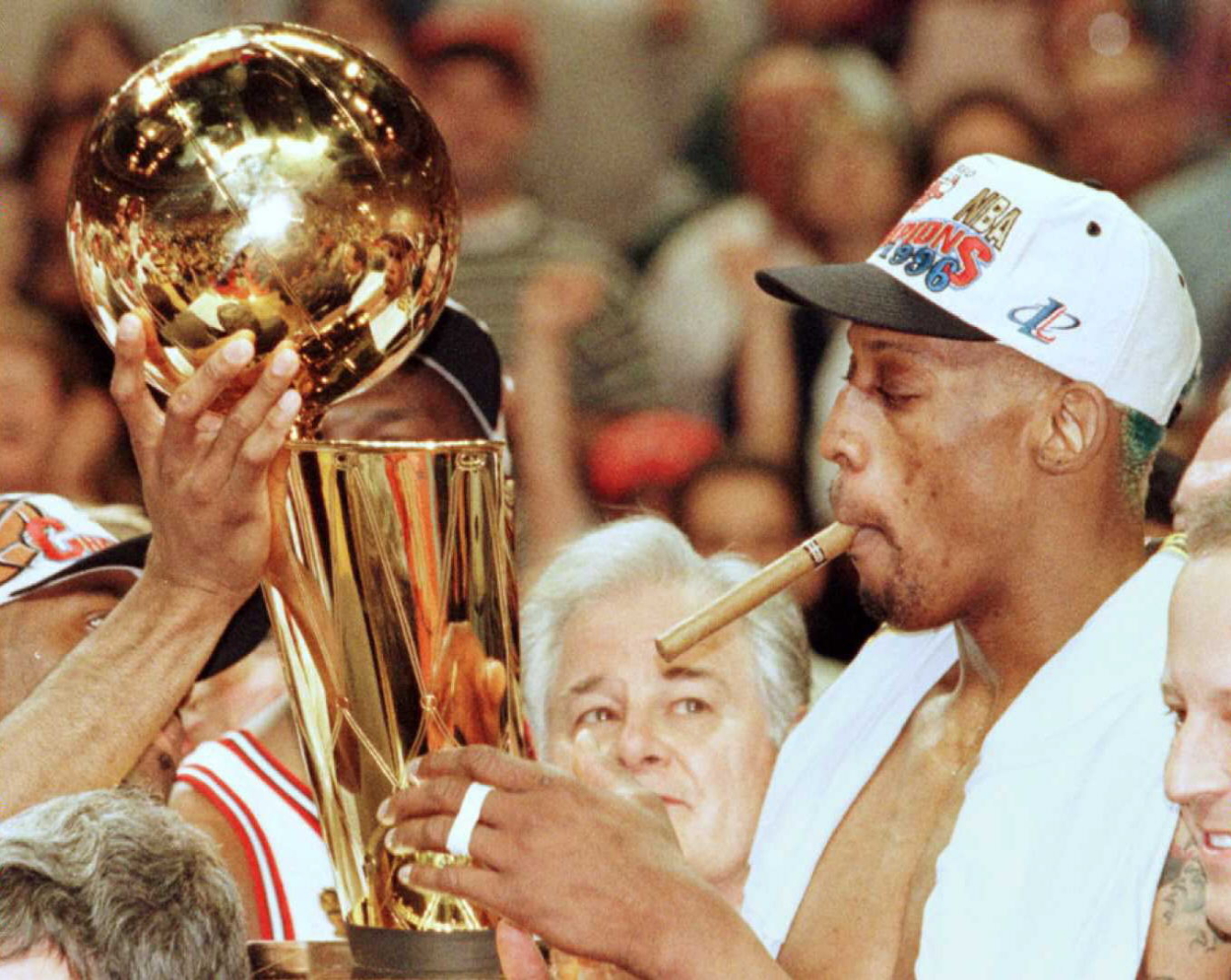 The Chicago Bulls' Dennis Rodman smokes a cigar after defeating the Seattle SuperSonics in Game 6 of the 1996 NBA Finals.