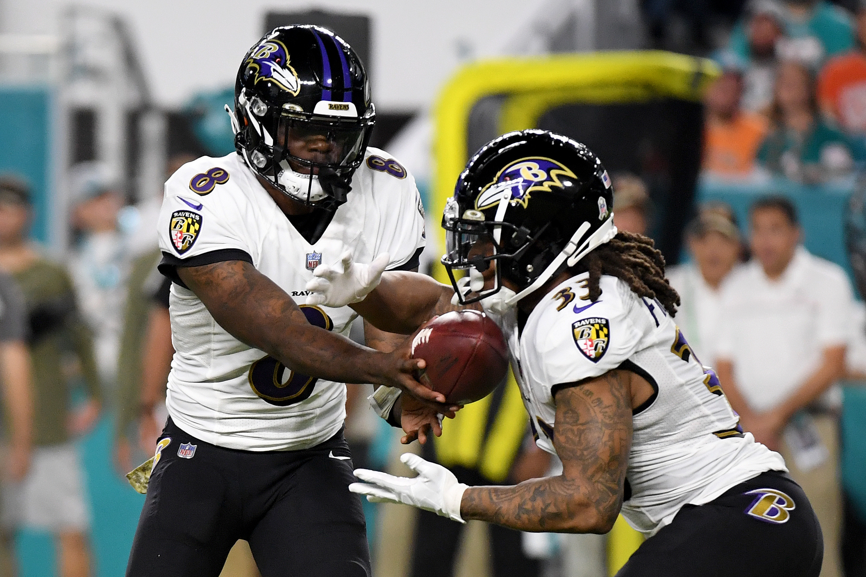 Ravens QB Lamar Jackson hands the ball to Devonta Freeman